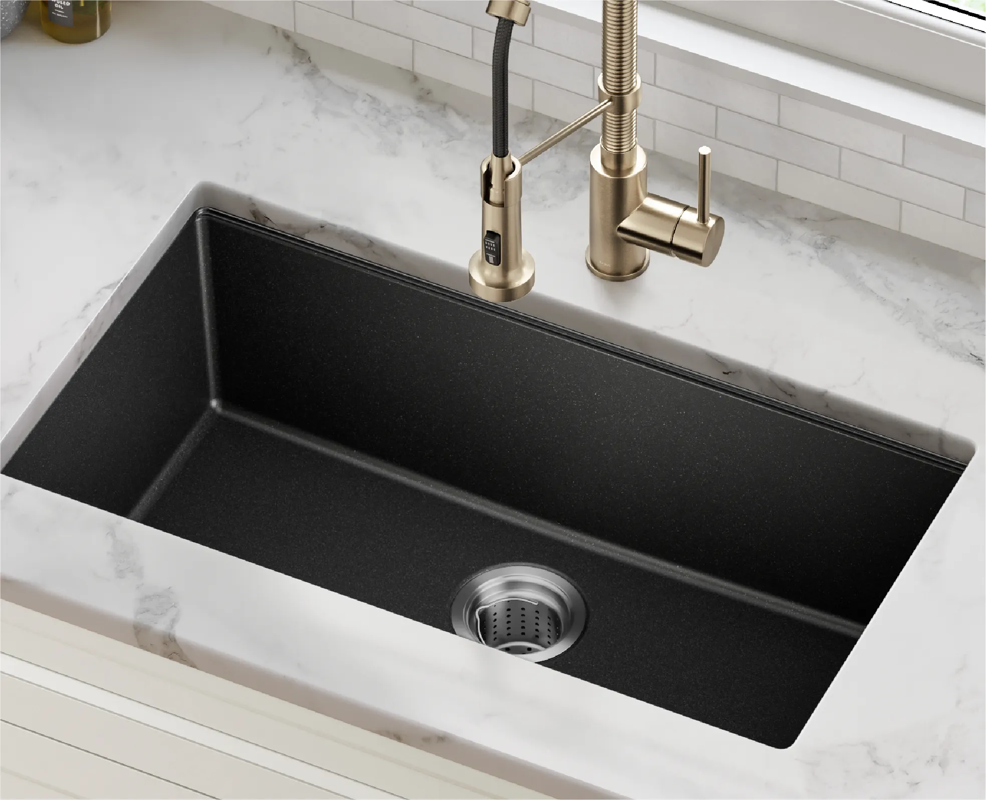 Black engineered stone sink paired with brass kitchen faucet