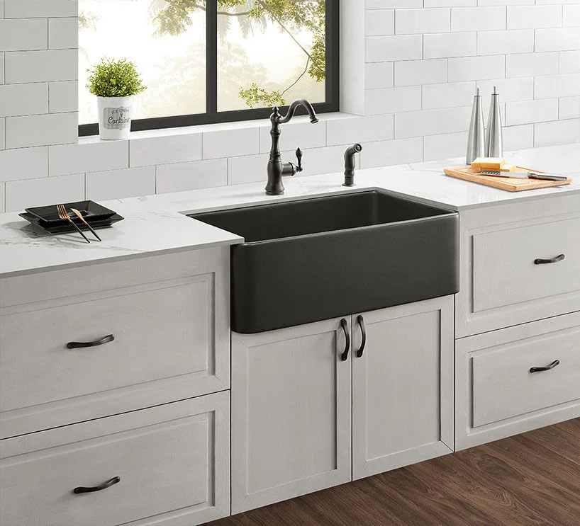 Black farmhouse apron front sink in white shaker kitchen