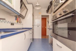 Contemporary galley kitchen with blue countertops and oven