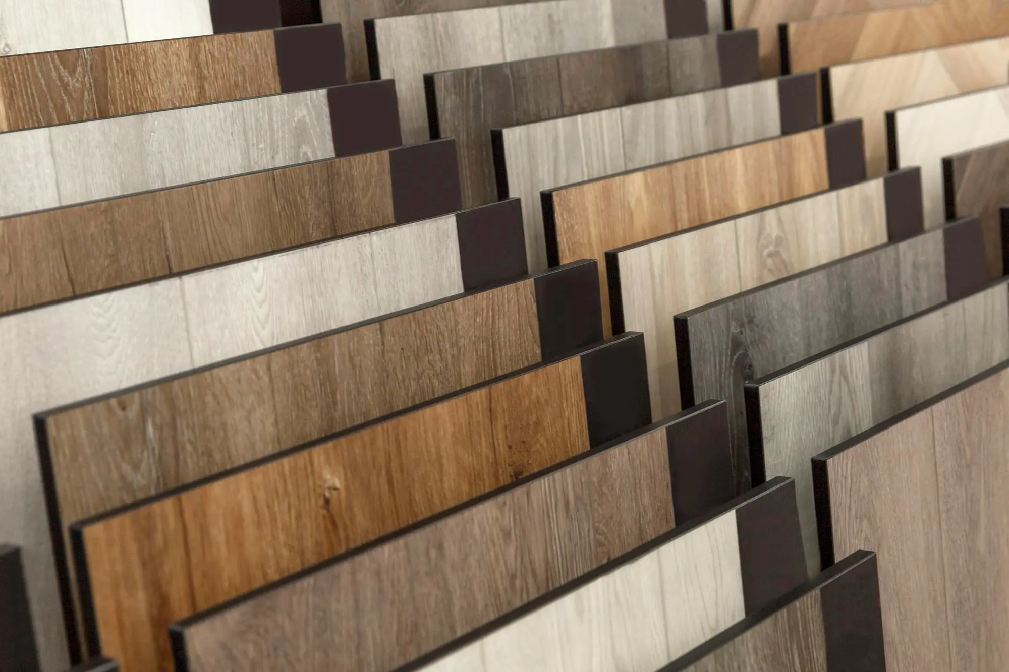 Display of assorted wood look flooring samples in rows
