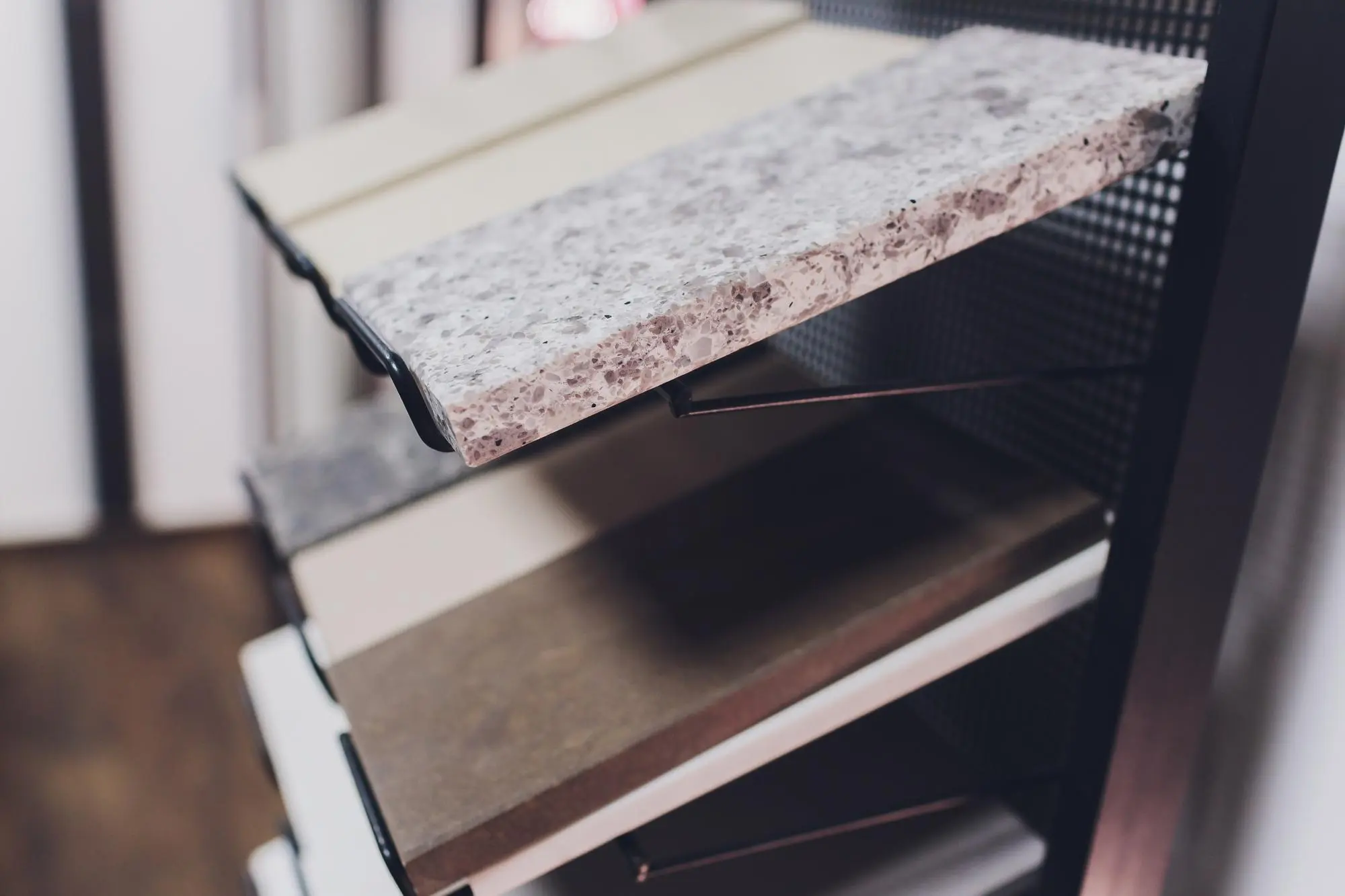Engineered stone sample boards stacked on metal display