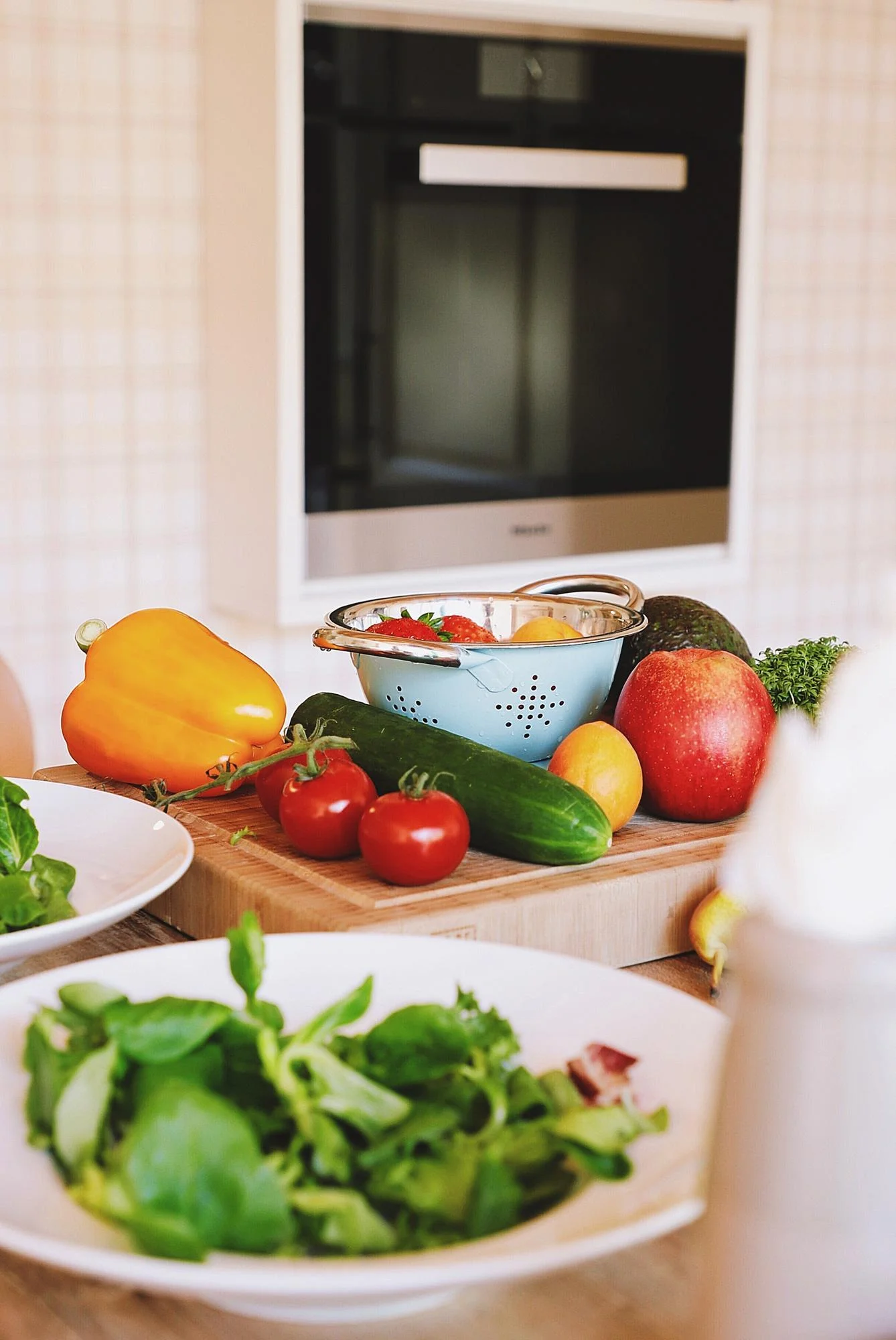 Fresh vegetables and salad bowls on a bright kitchen counter