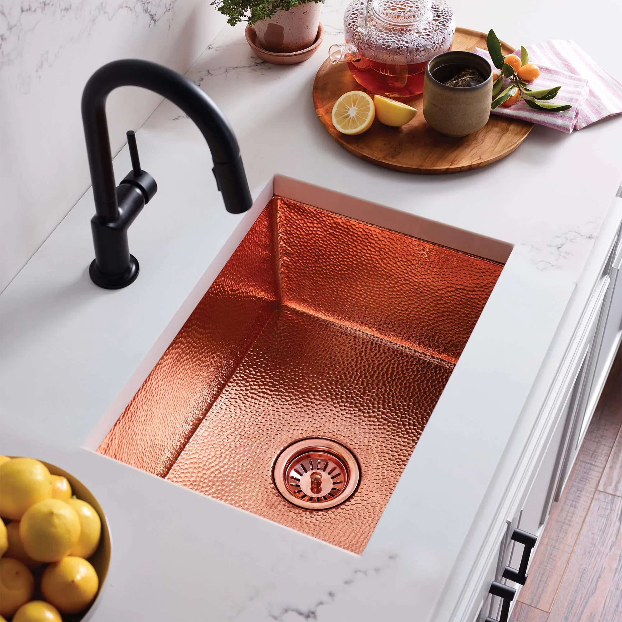 Hammered copper kitchen sink with matte black faucet