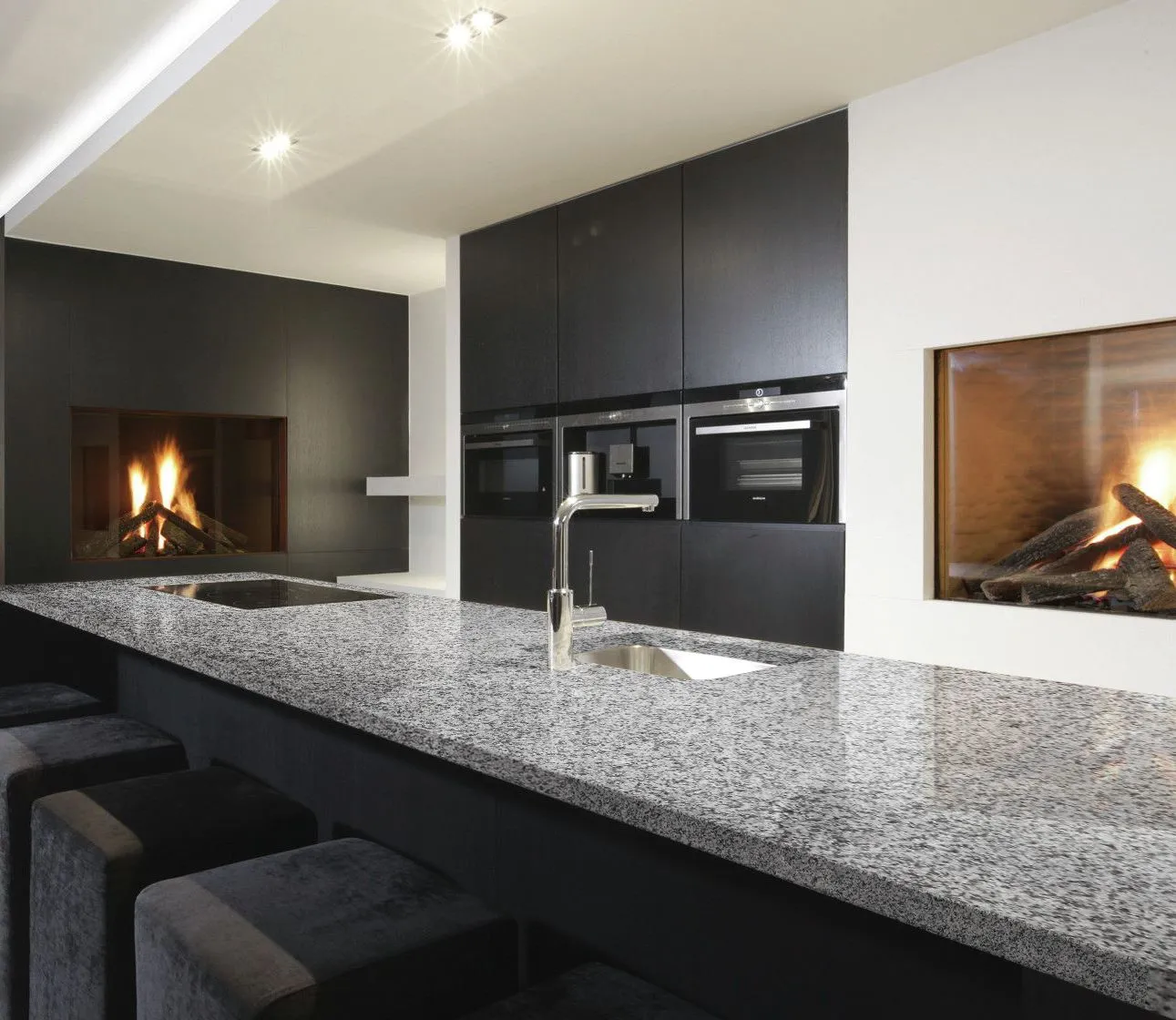 Modern dark kitchen featuring sleek gray granite counter