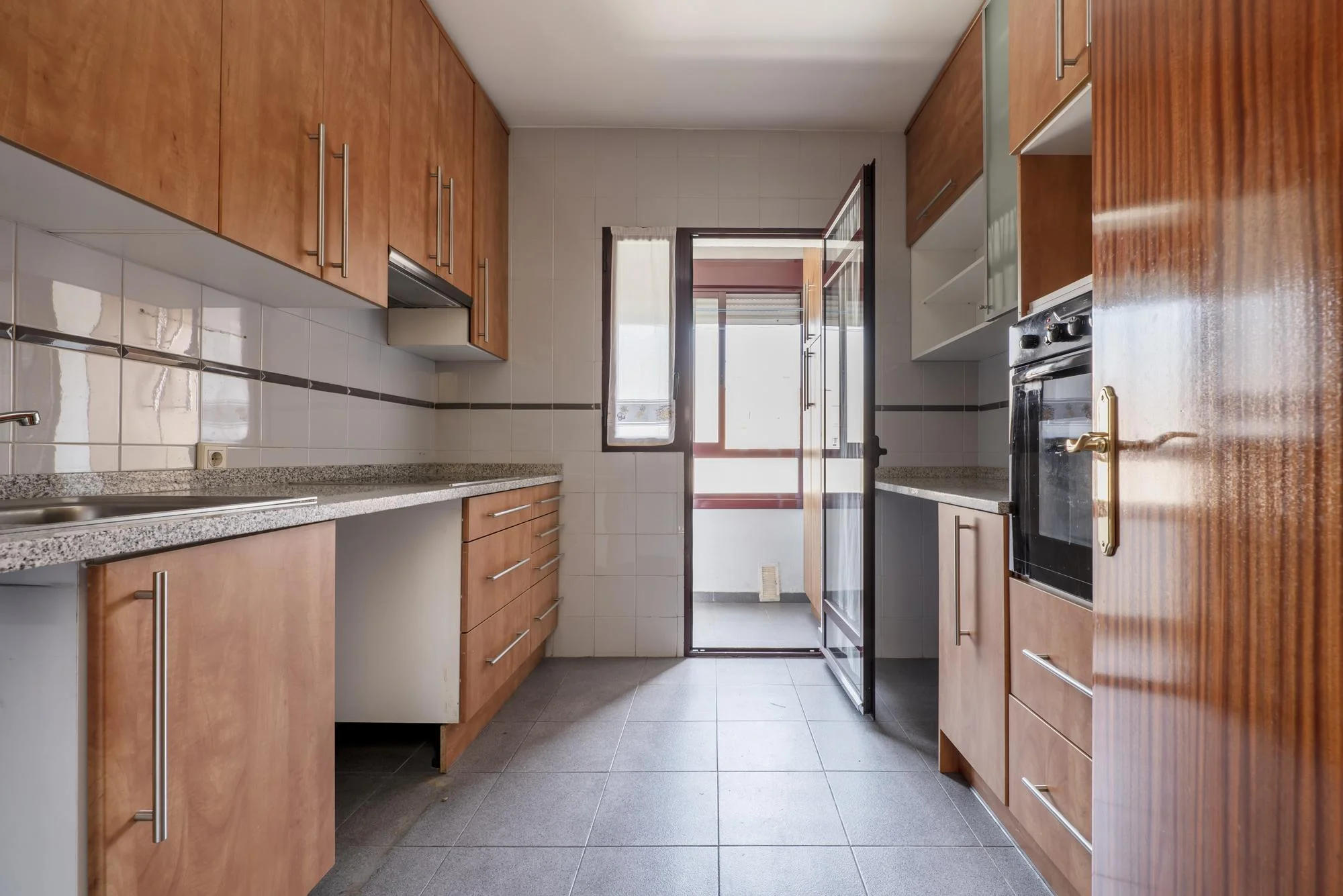 Modern galley kitchen with granite countertop and window