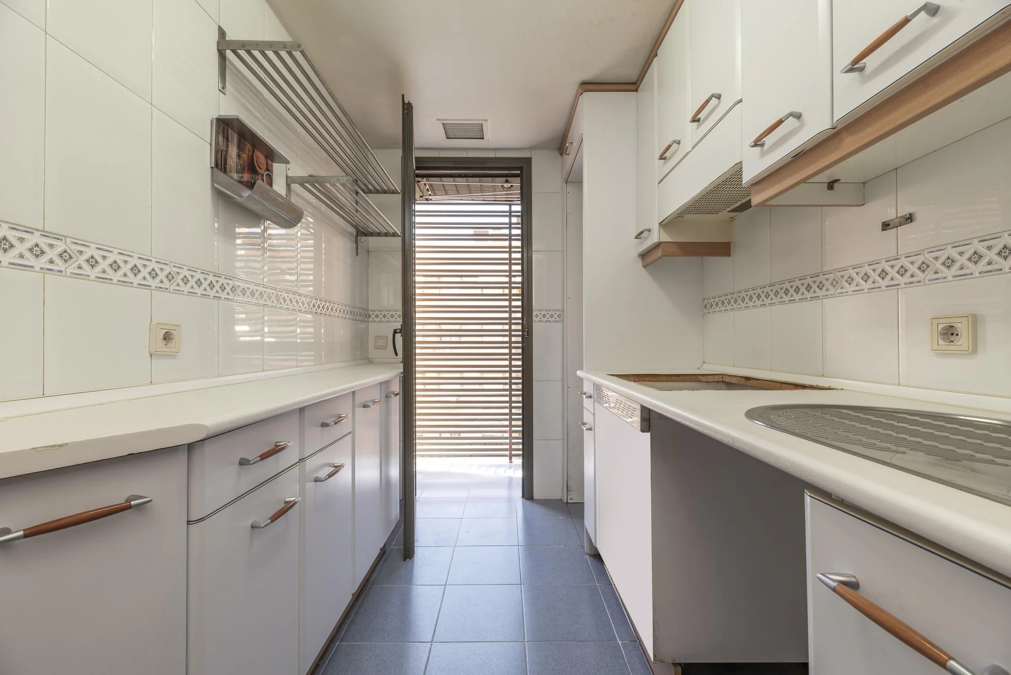 Narrow white galley kitchen with tiled backsplash design
