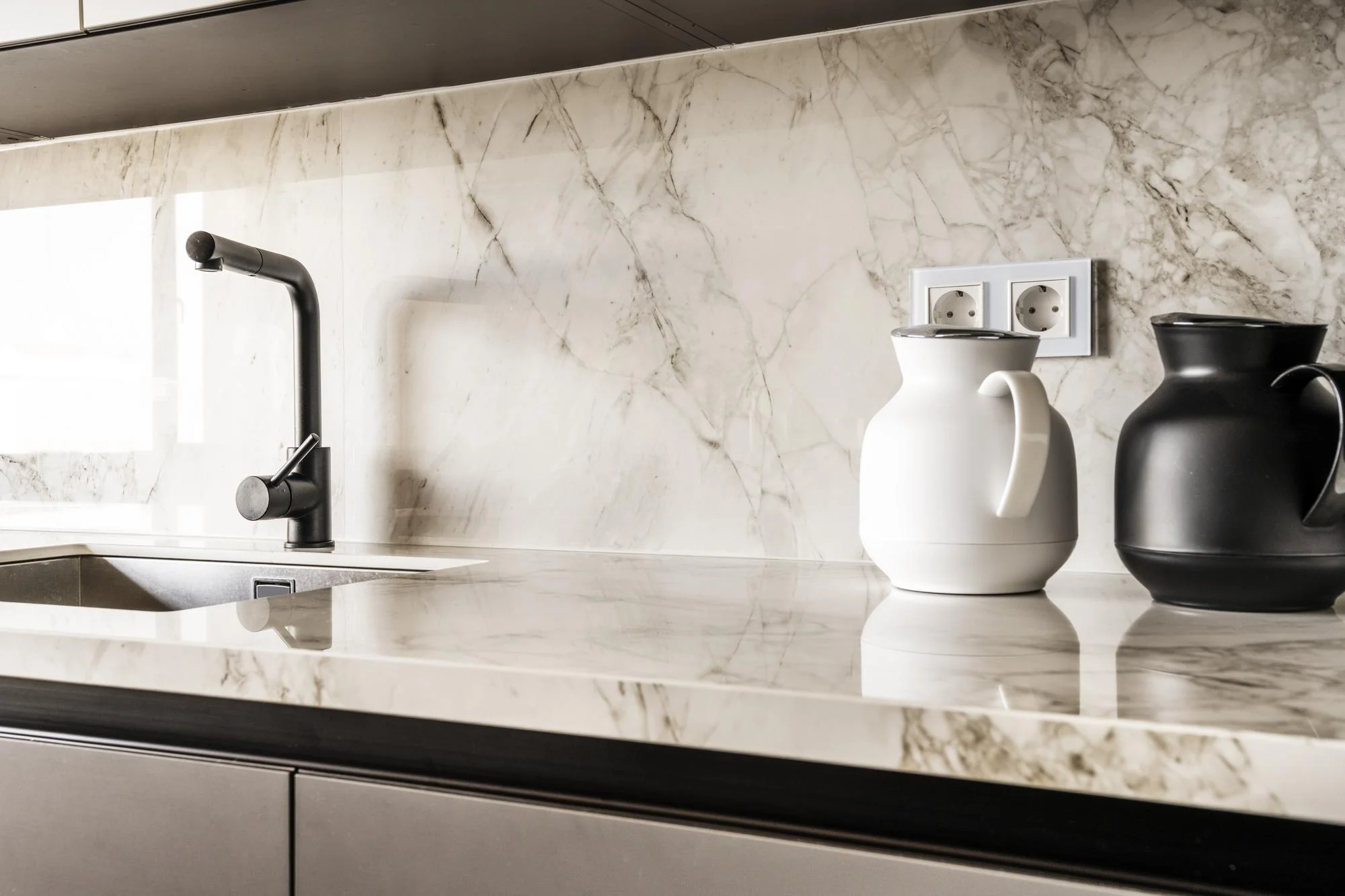 Polished marble backsplash with soft grey veining