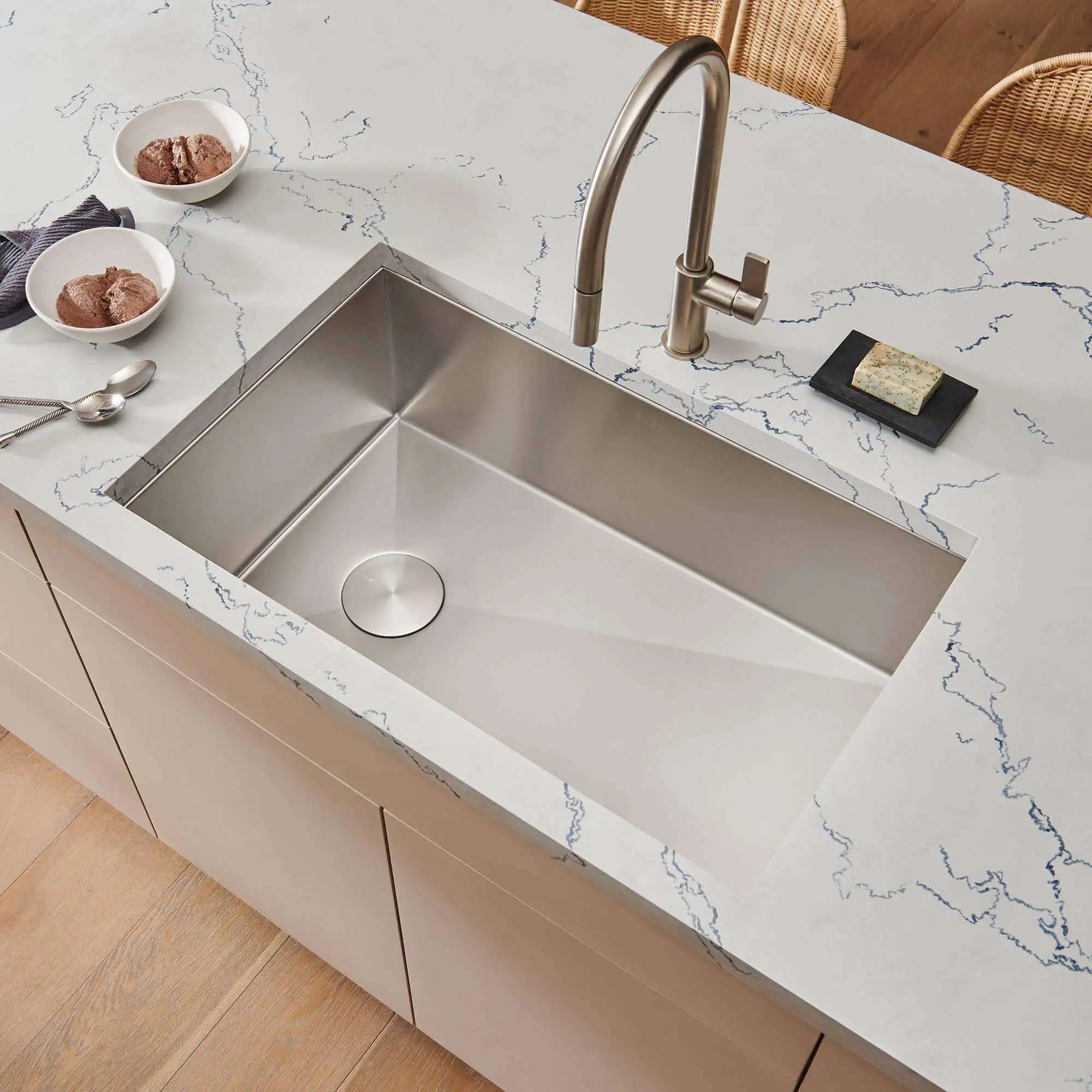 Sleek undermount steel sink in white quartz countertop