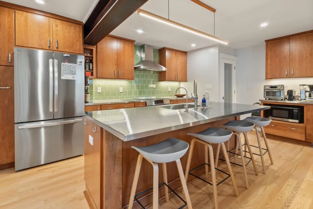 Stainless steel kitchen island in warm wood cabinet space