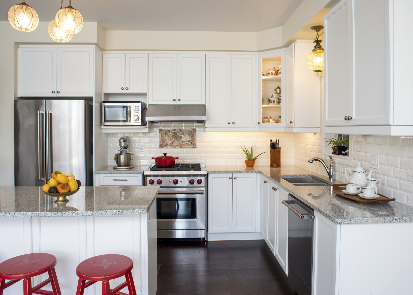 White modern kitchen with subway tiles and stainless appliances