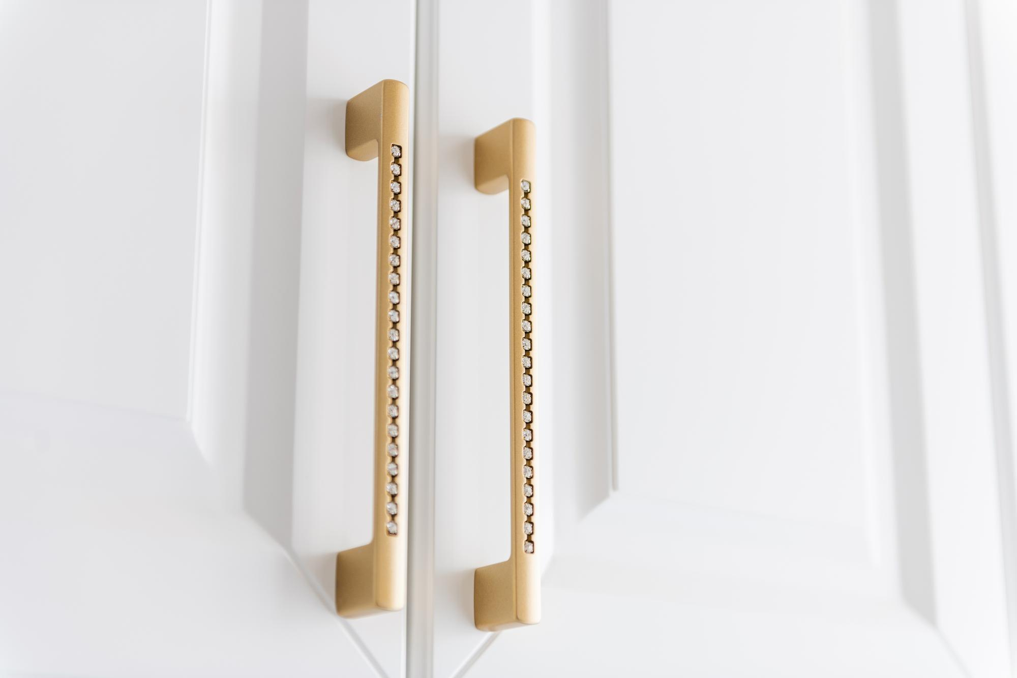 Brass pull handles on white kitchen cabinets