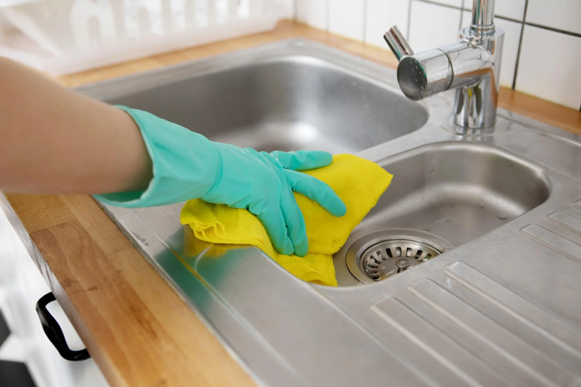 Cleaning stainless steel kitchen sink with glove