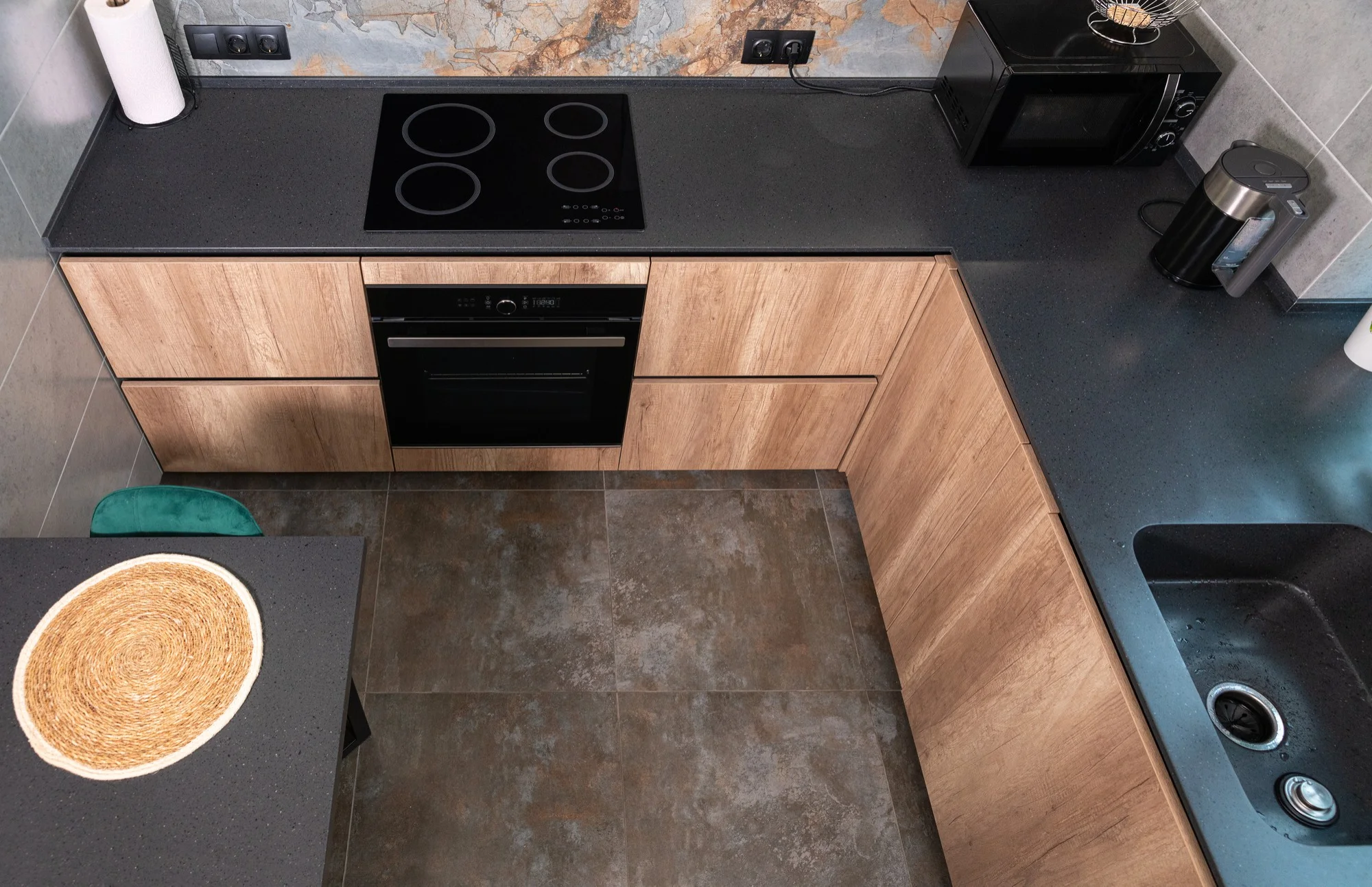 Compact U shaped kitchen with wood cabinets and dark top