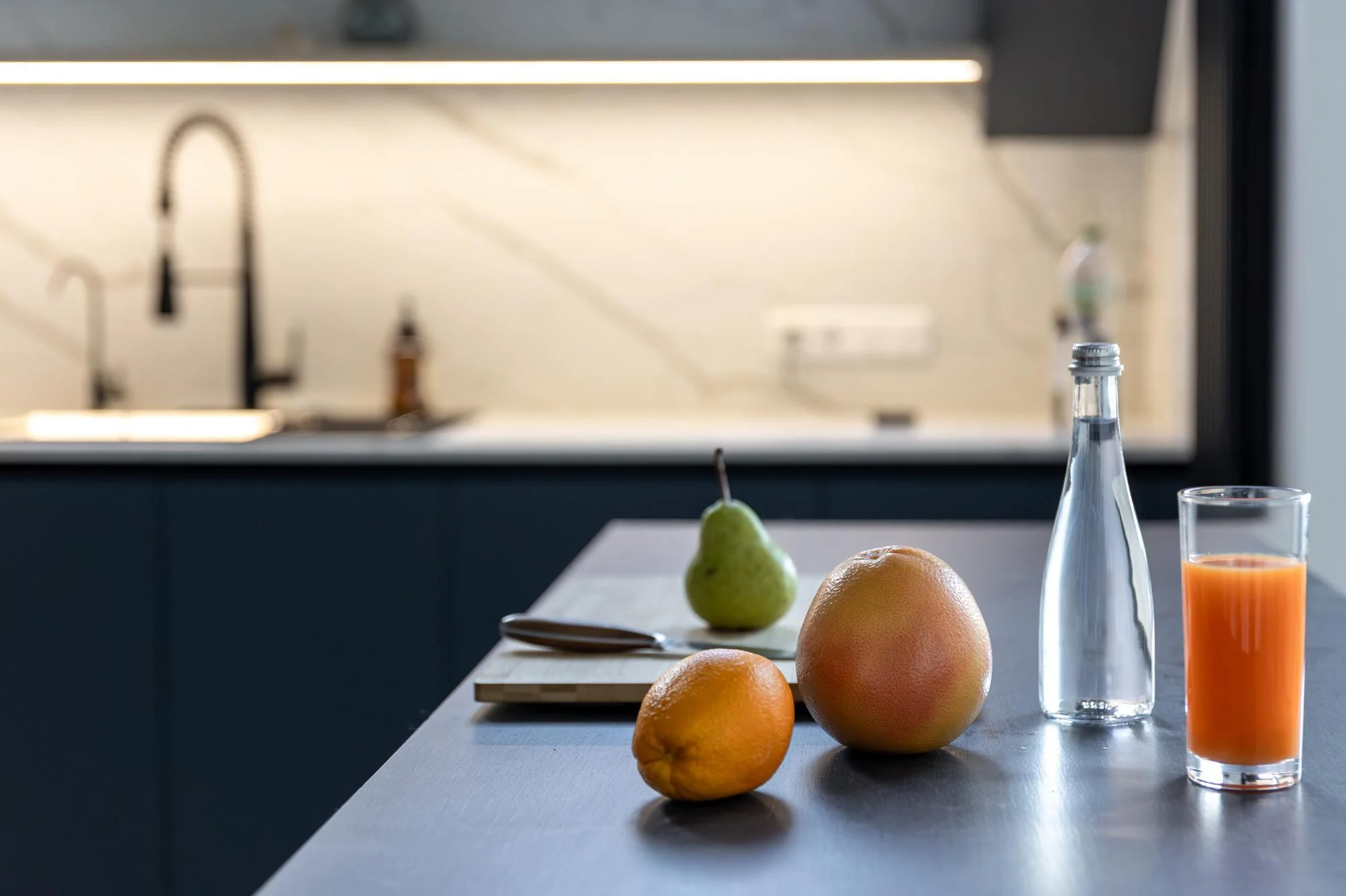 Narrow kitchen counter setup with sink and tall cabinets