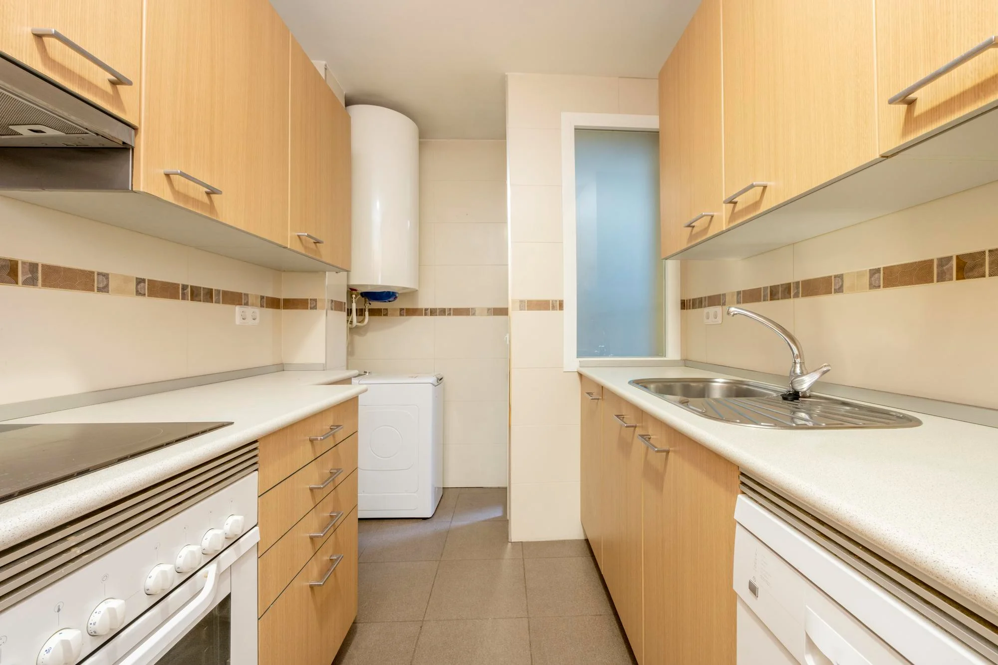 Narrow prefab kitchen with wood cabinets and appliances