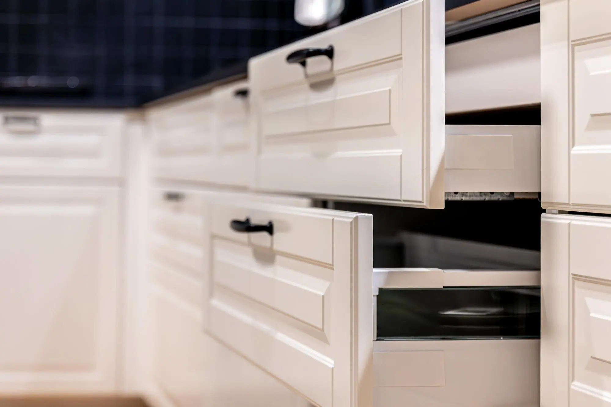White kitchen drawers opened to show deep storage design White kitchen drawers opened to show deep storage design