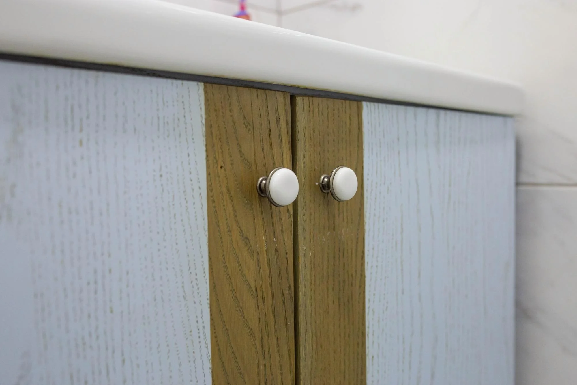 White round knobs on light wood cabinet doors