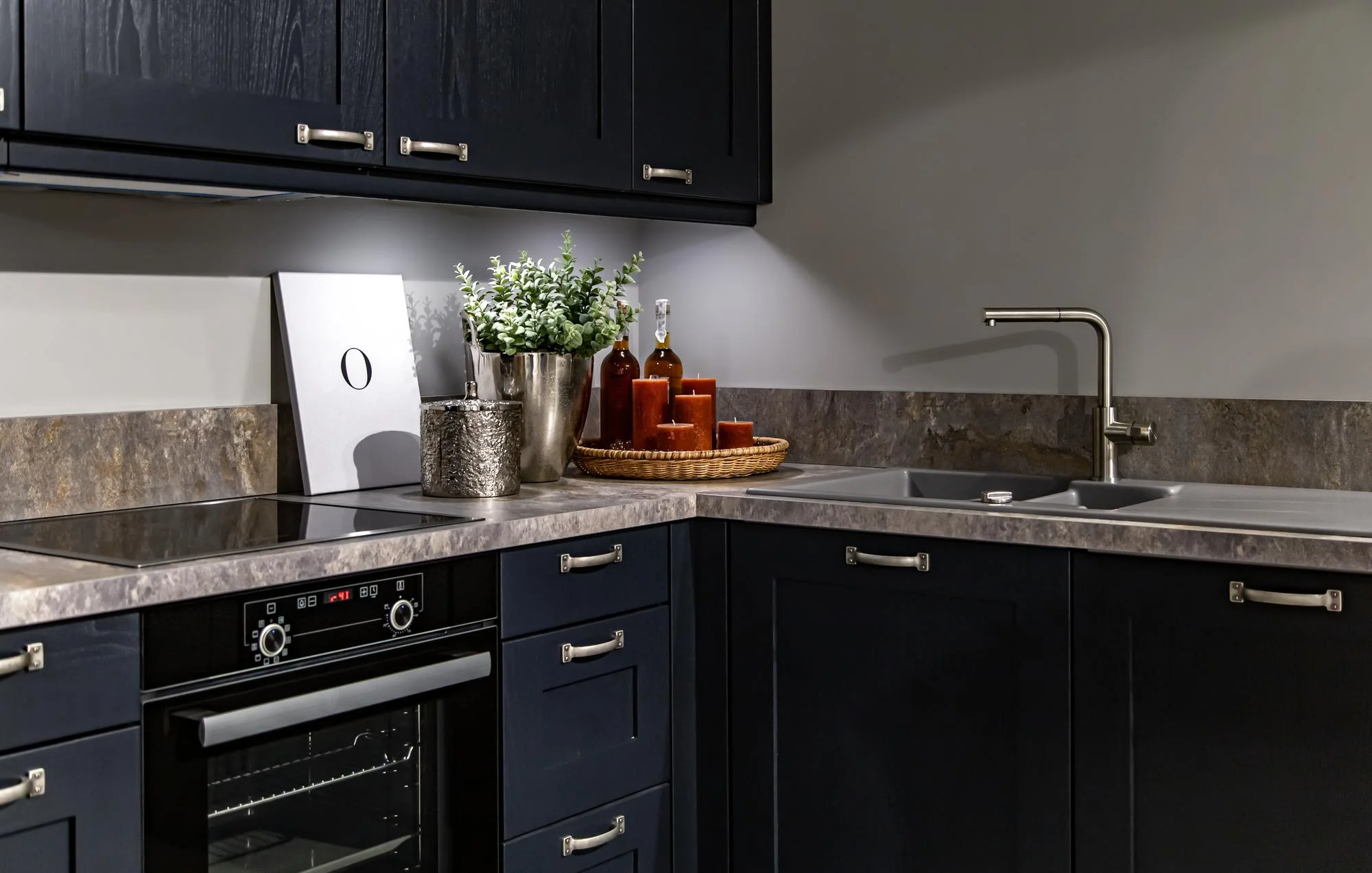 Gray granite countertop with dark blue cabinets and sink