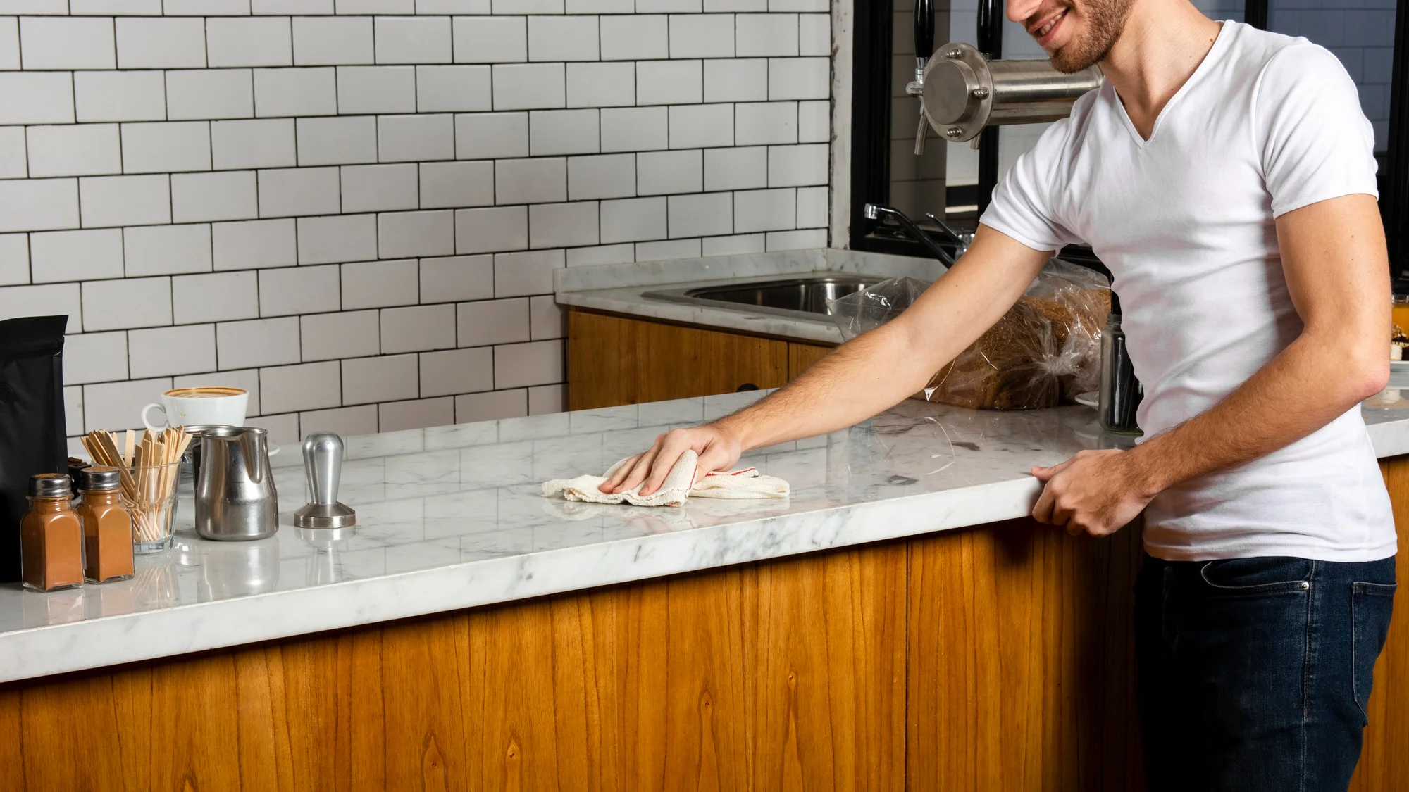 Man wiping a white marble countertop with a cloth