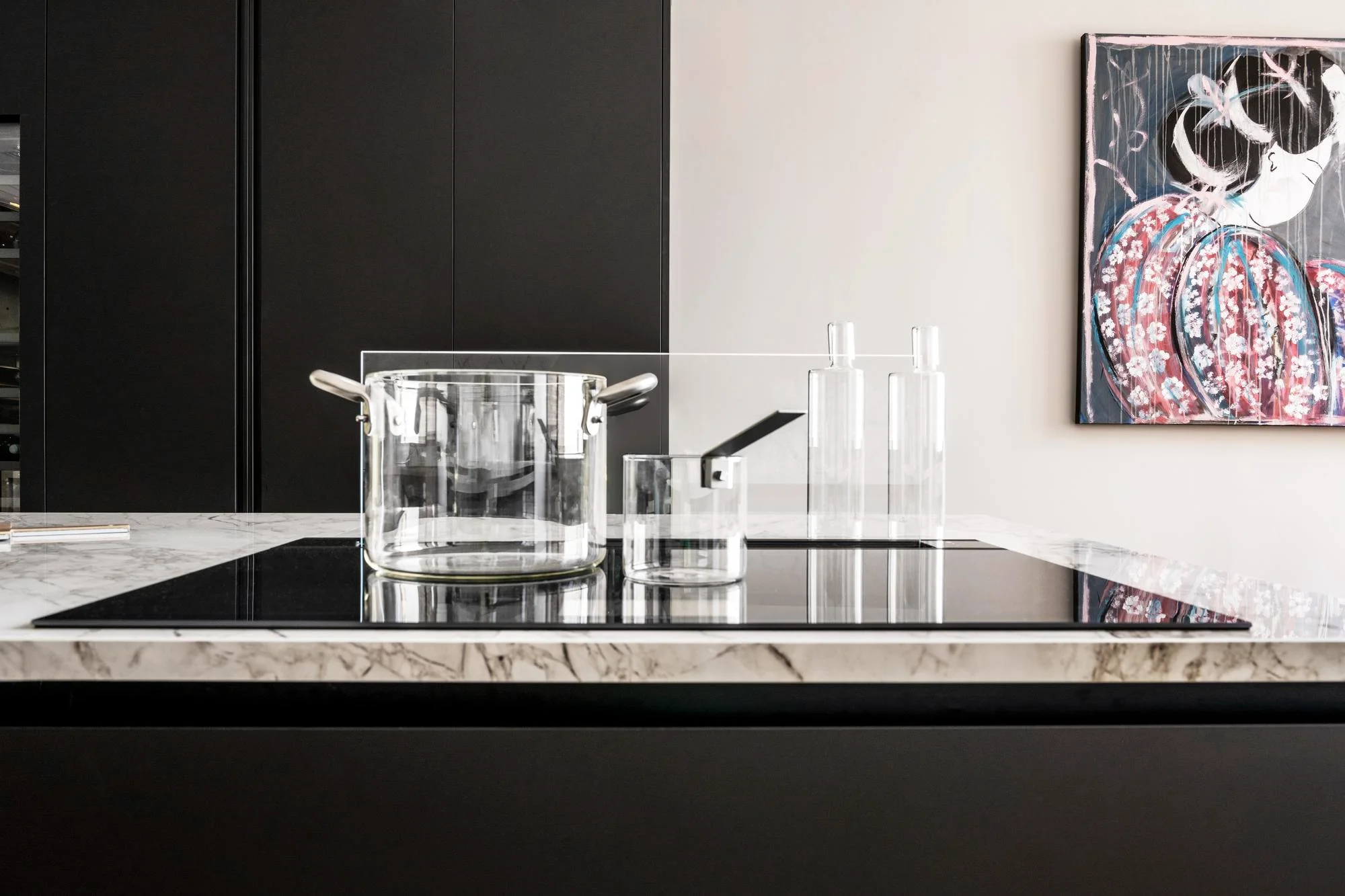 Marble countertop with a glass pot on a black cooktop