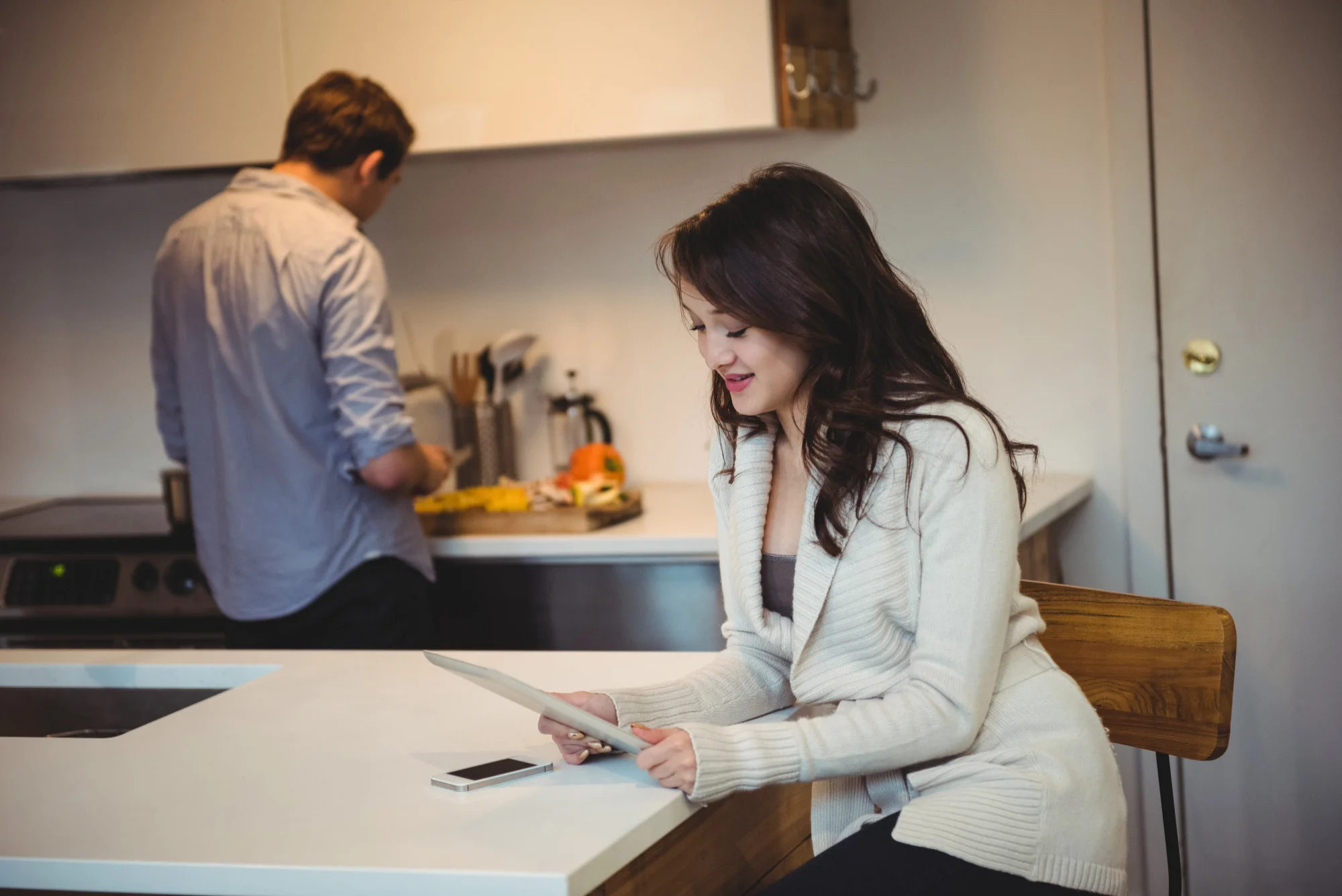Woman reviewing kitchen renovation plans at island