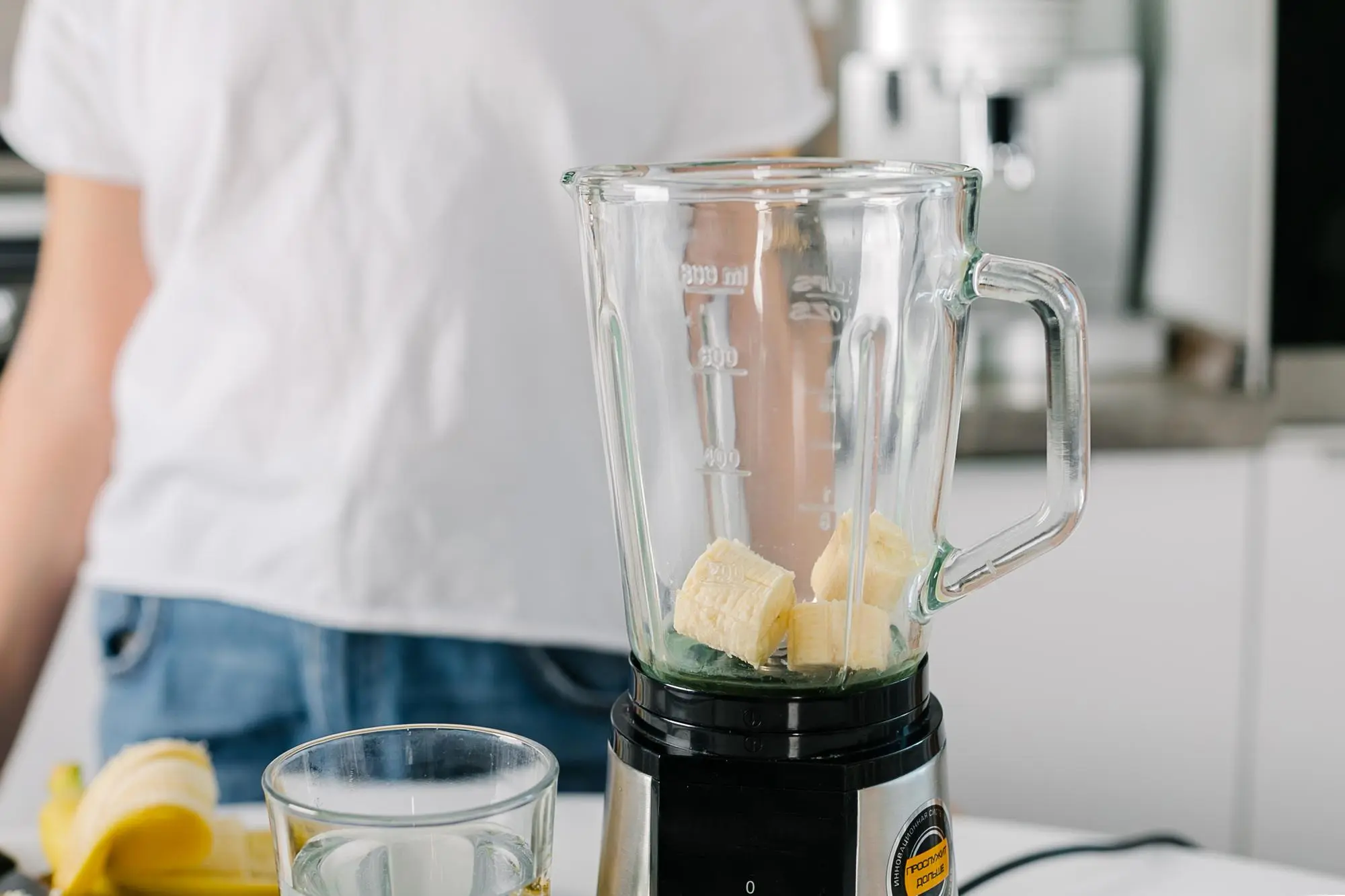 Licuadora con trozos de plátano sobre la encimera de la cocina.