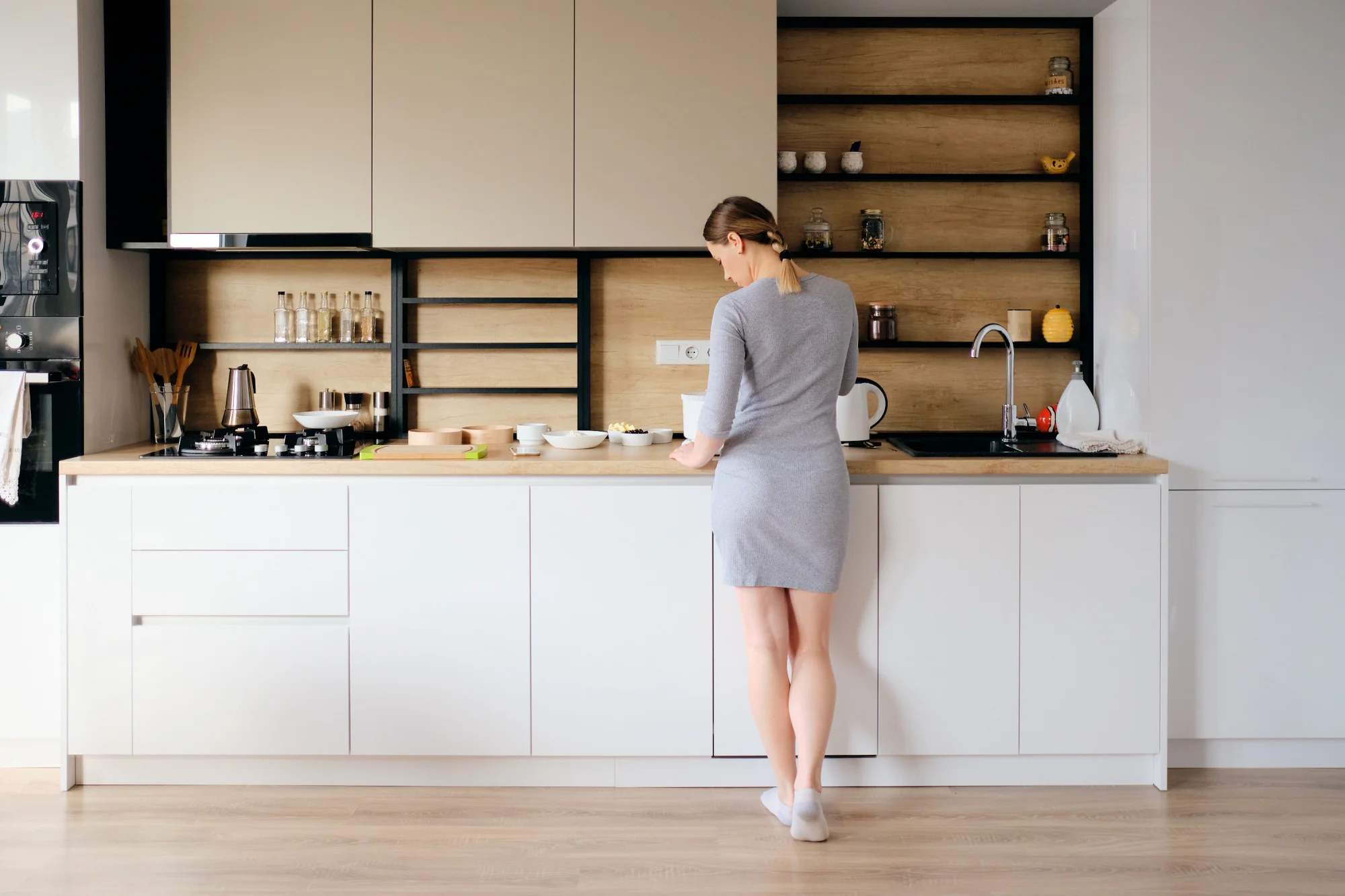 Minimalist kitchen with light cabinets and wood accents