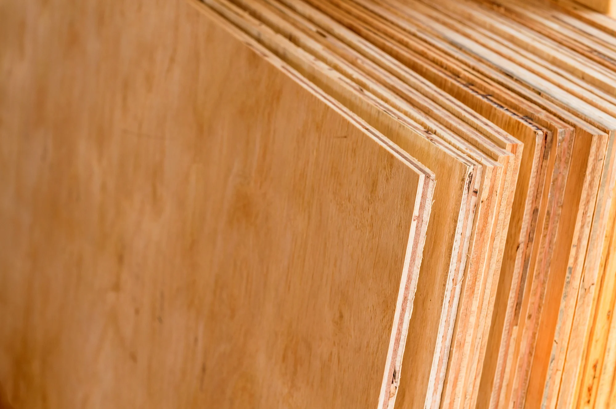 Stacked plywood sheets showing layered structure Stacked plywood sheets showing layered structure