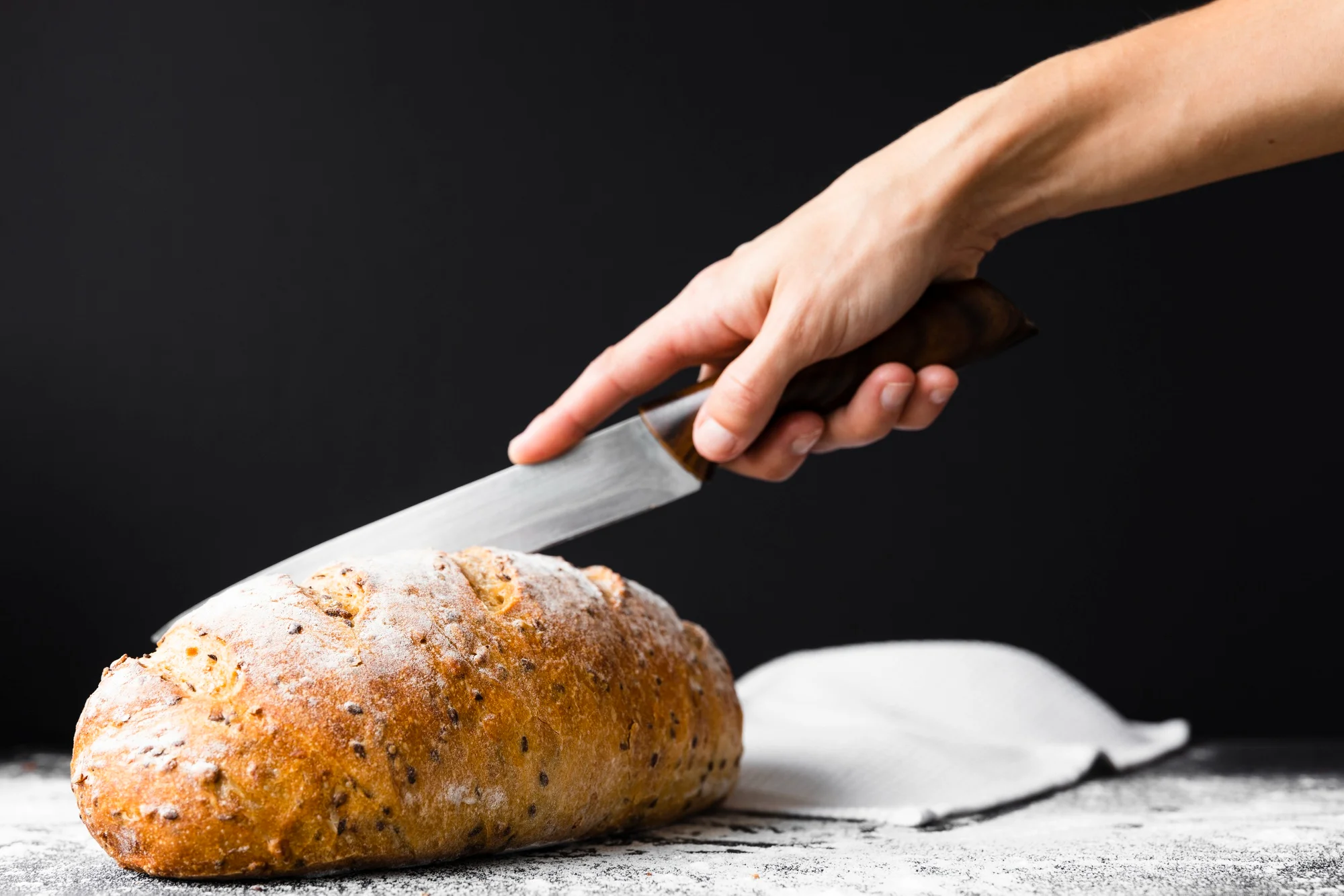 Bread knife slicing fresh artisan loaf