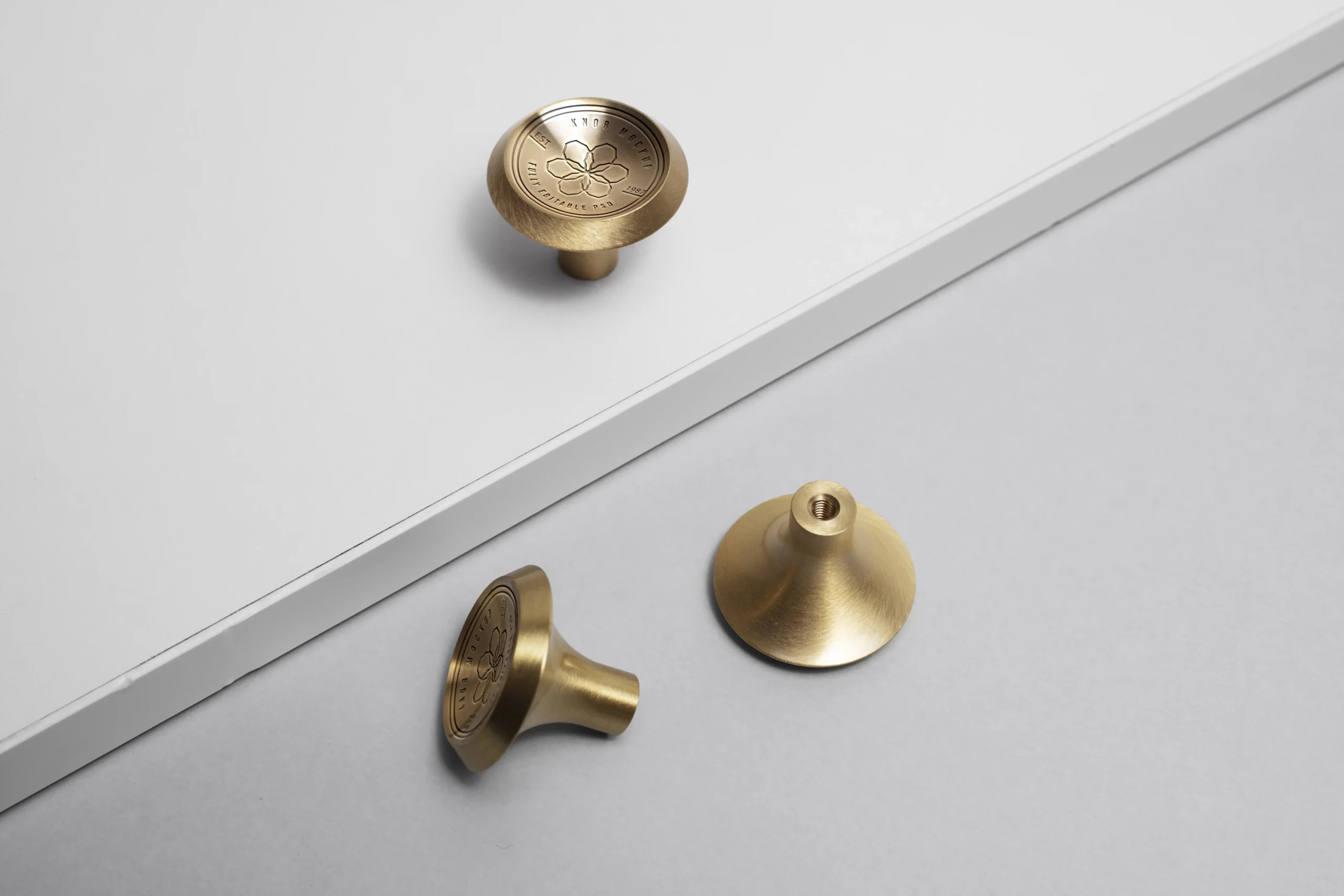 Brushed gold cabinet knobs on white surface