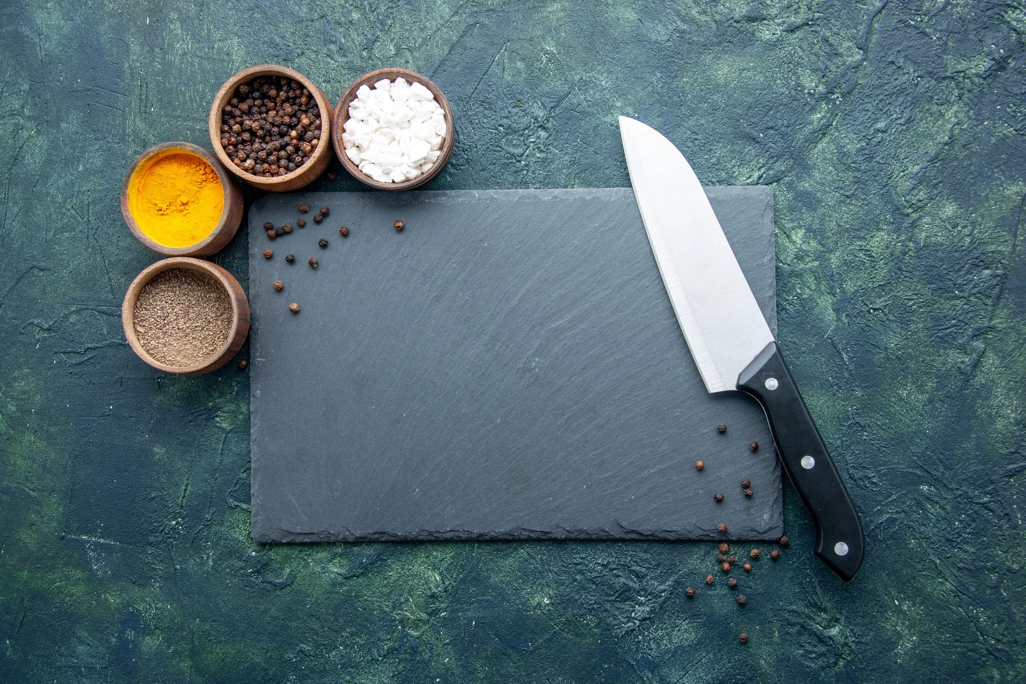 Chef knife on cutting board with spices