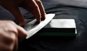 شحذ سكين الطاهي على حجر الشحذ (لقطة مقرّبة)