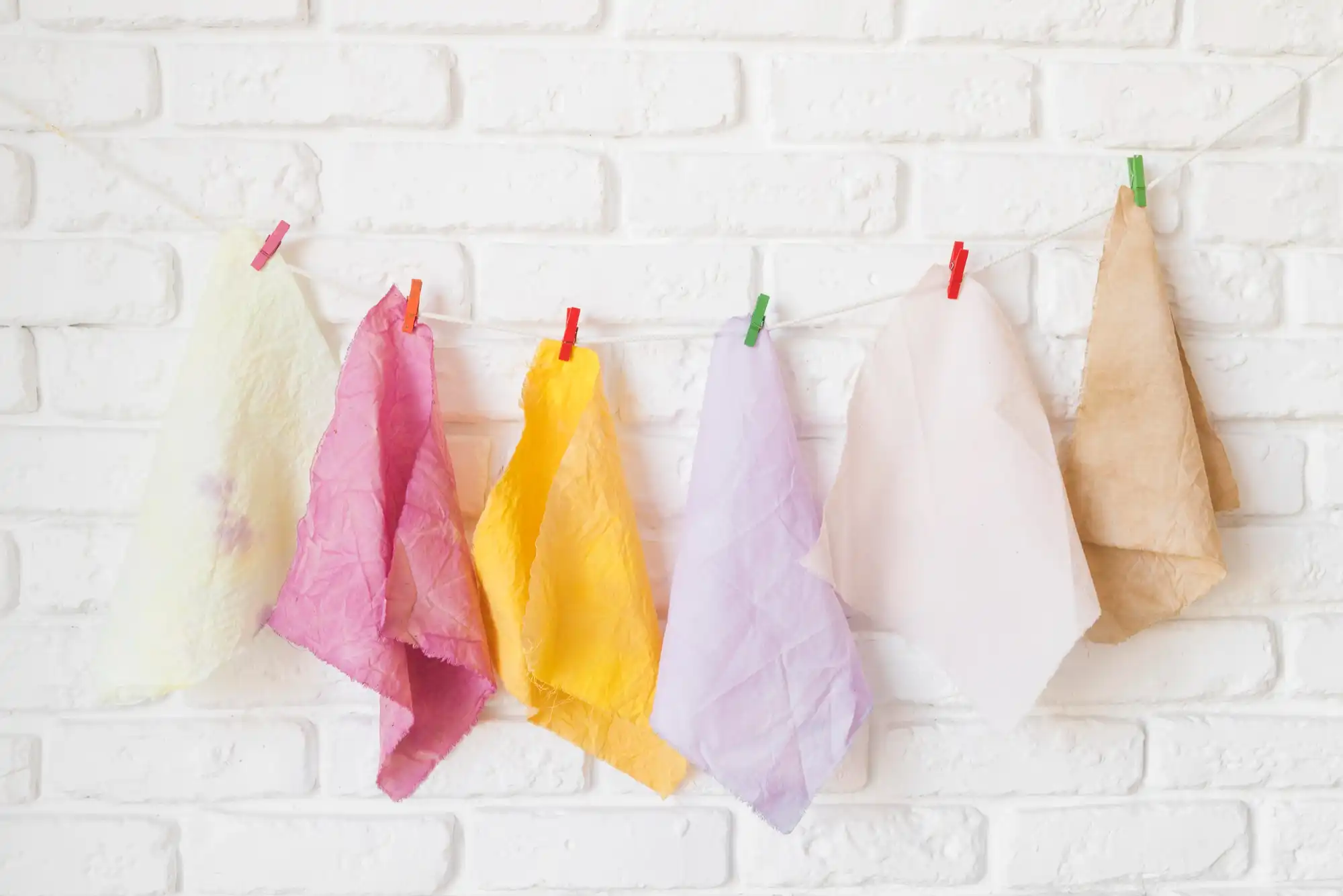 Des torchons colorés réutilisables suspendus à la corde à linge de la cuisine