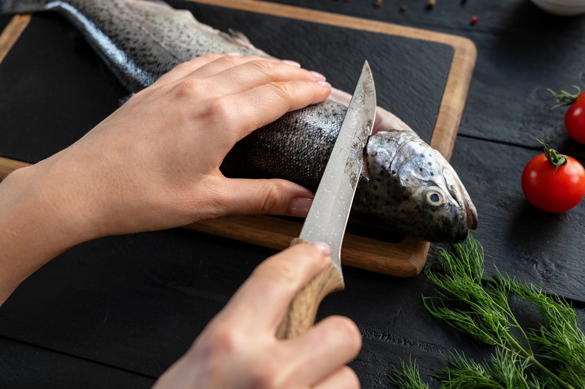 Fillet knife cutting fresh fish on board