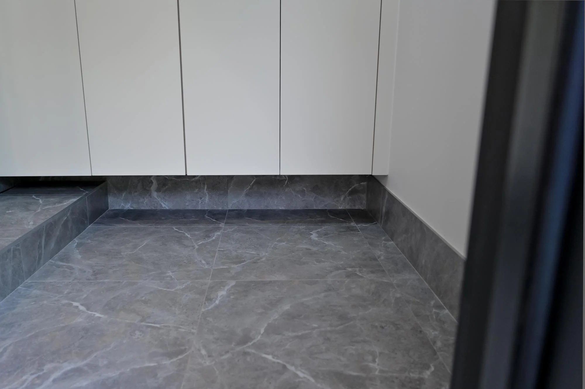 Pavimento della cucina in piastrelle di porcellana grigia sotto i pensili