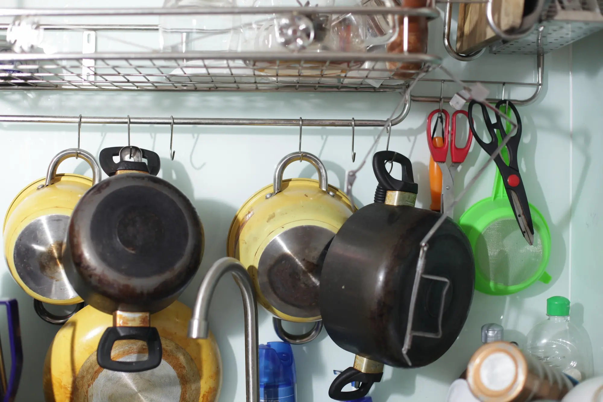 Hanging pots and pans organized on kitchen wall rack
