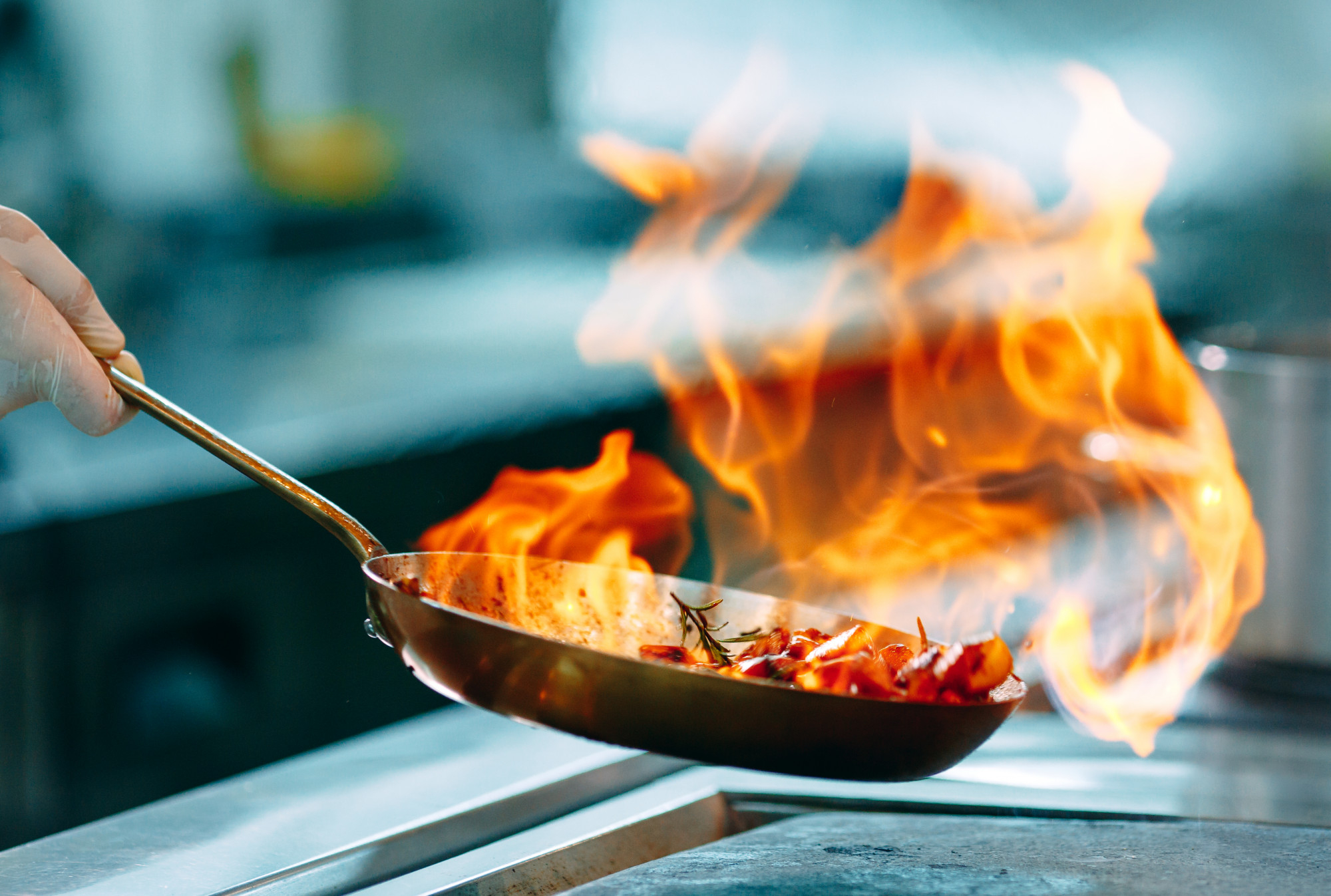 Padella in fiamme che indica un rischio di pericolo in cucina