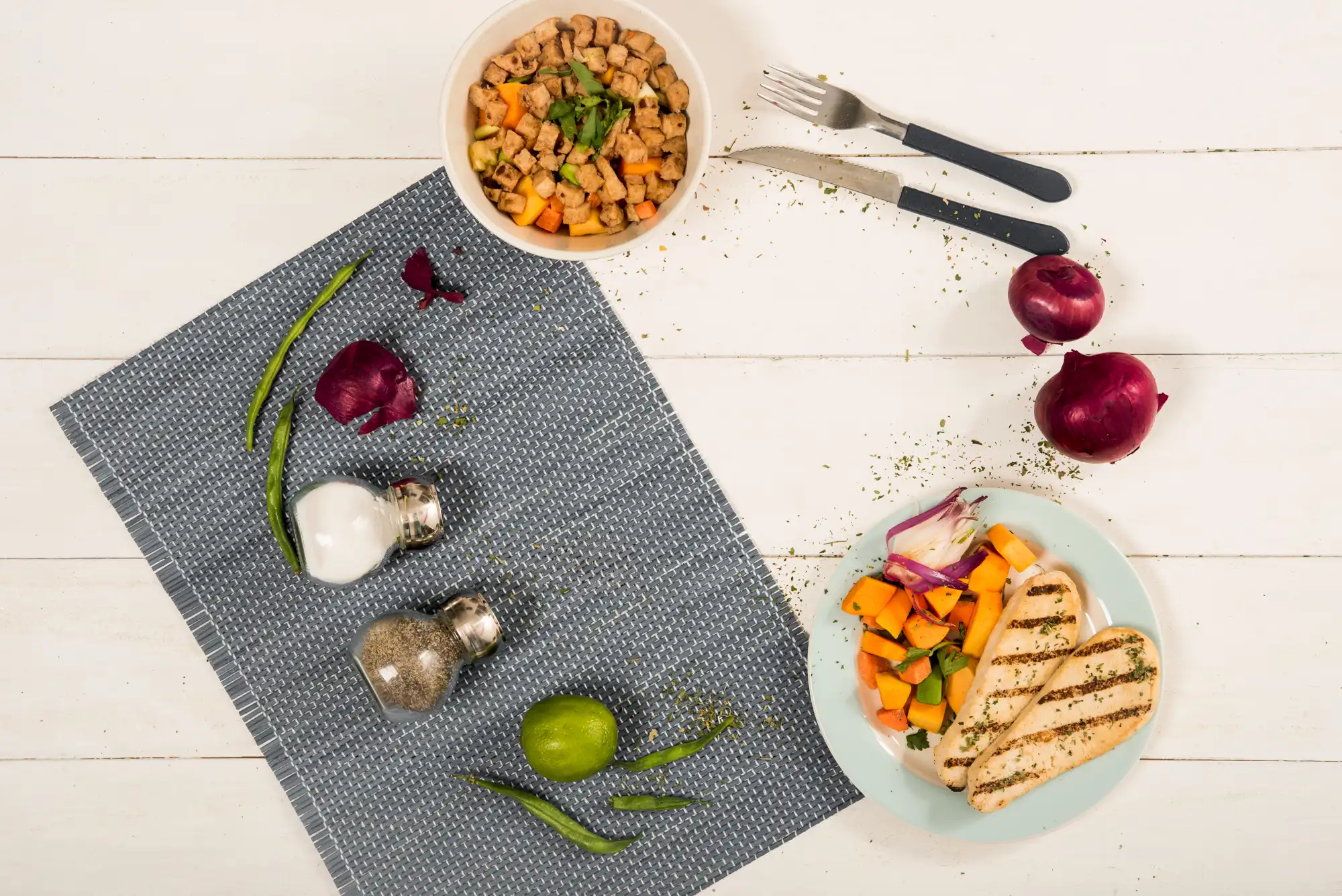 Sets de table avec le repas dressé sur une table en bois blanc