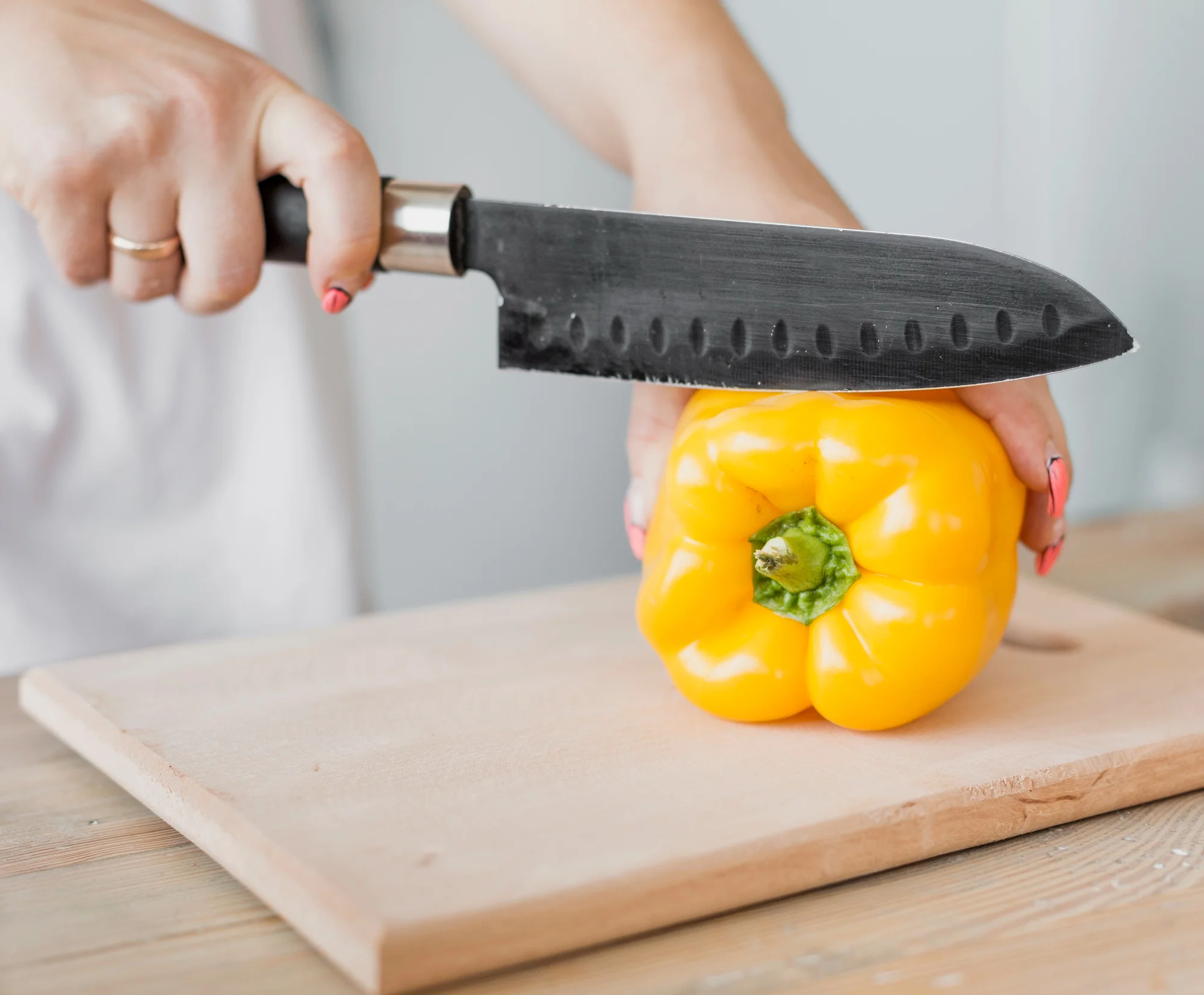 Santoku knife slicing yellow bell pepper