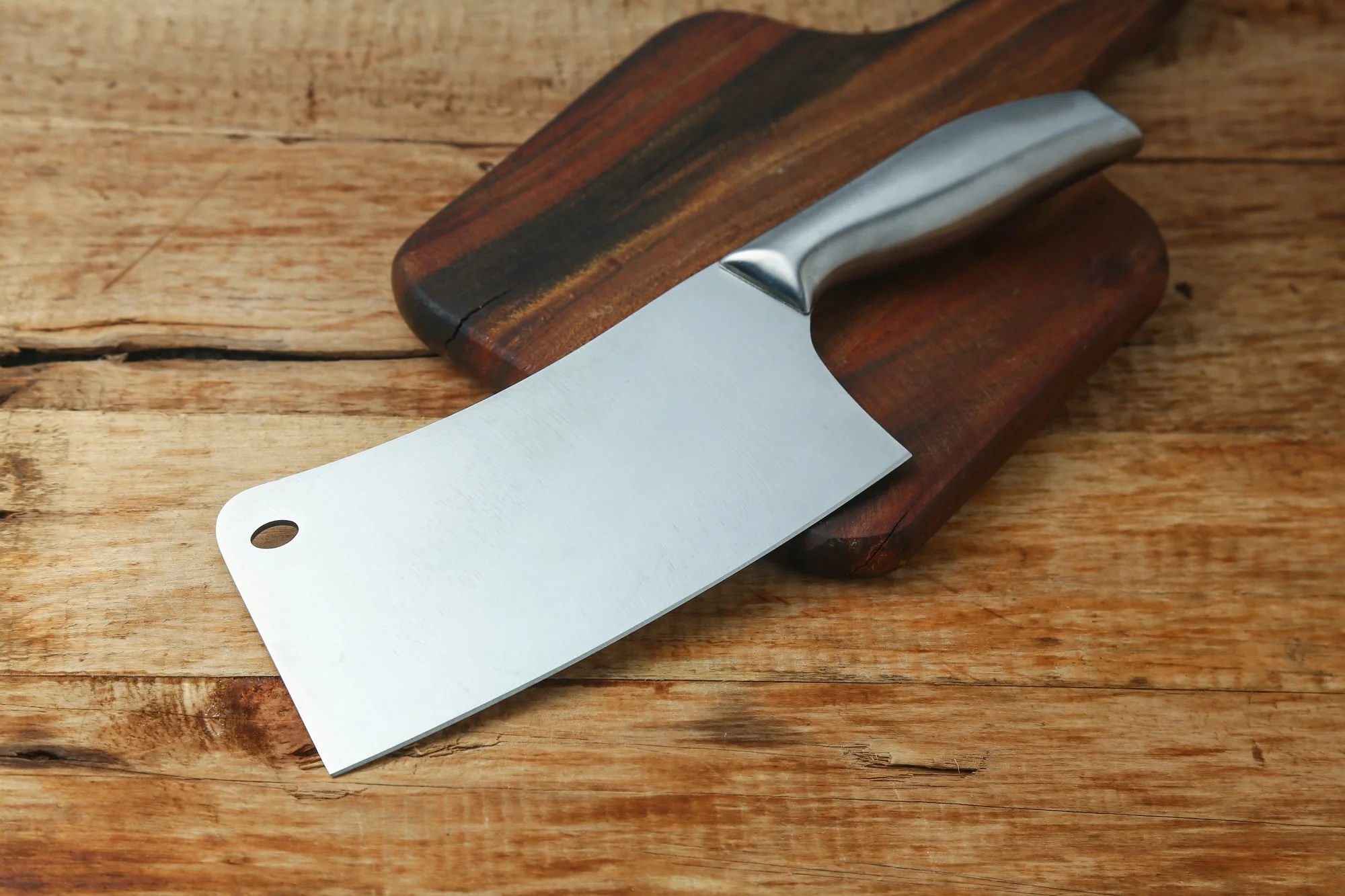 Stainless steel cleaver on wooden board