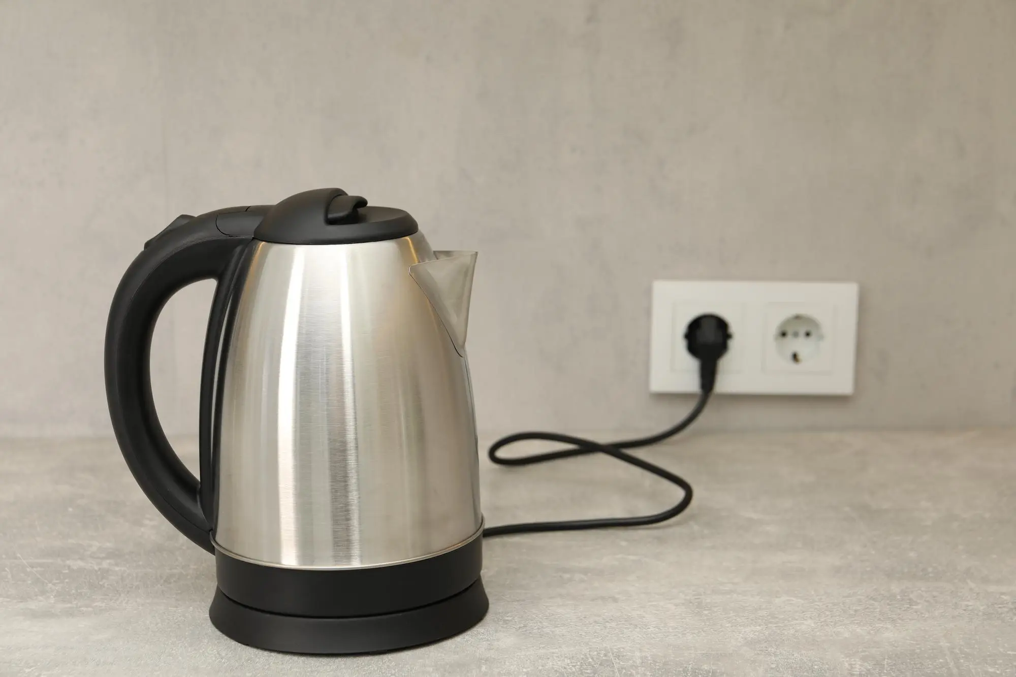 غلاية كهربائية من الفولاذ المقاوم للصدأ على سطح طاولة المطبخ