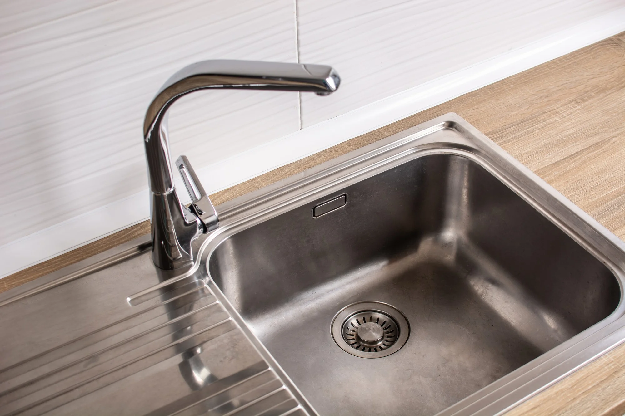 Stainless steel sink with built in drainboard and faucet