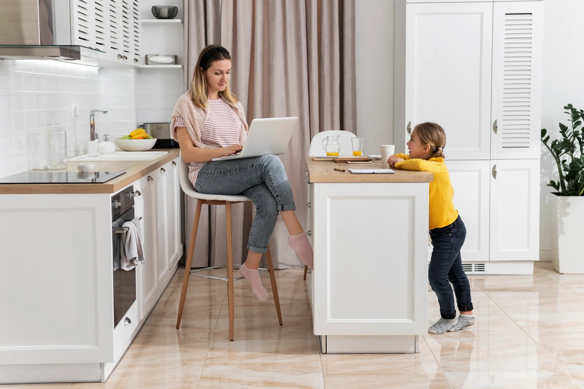 Donna e bambino seduti in una cucina luminosa con piastrelle lucide sul pavimento. Donna e bambino seduti in una cucina luminosa con piastrelle lucide sul pavimento.