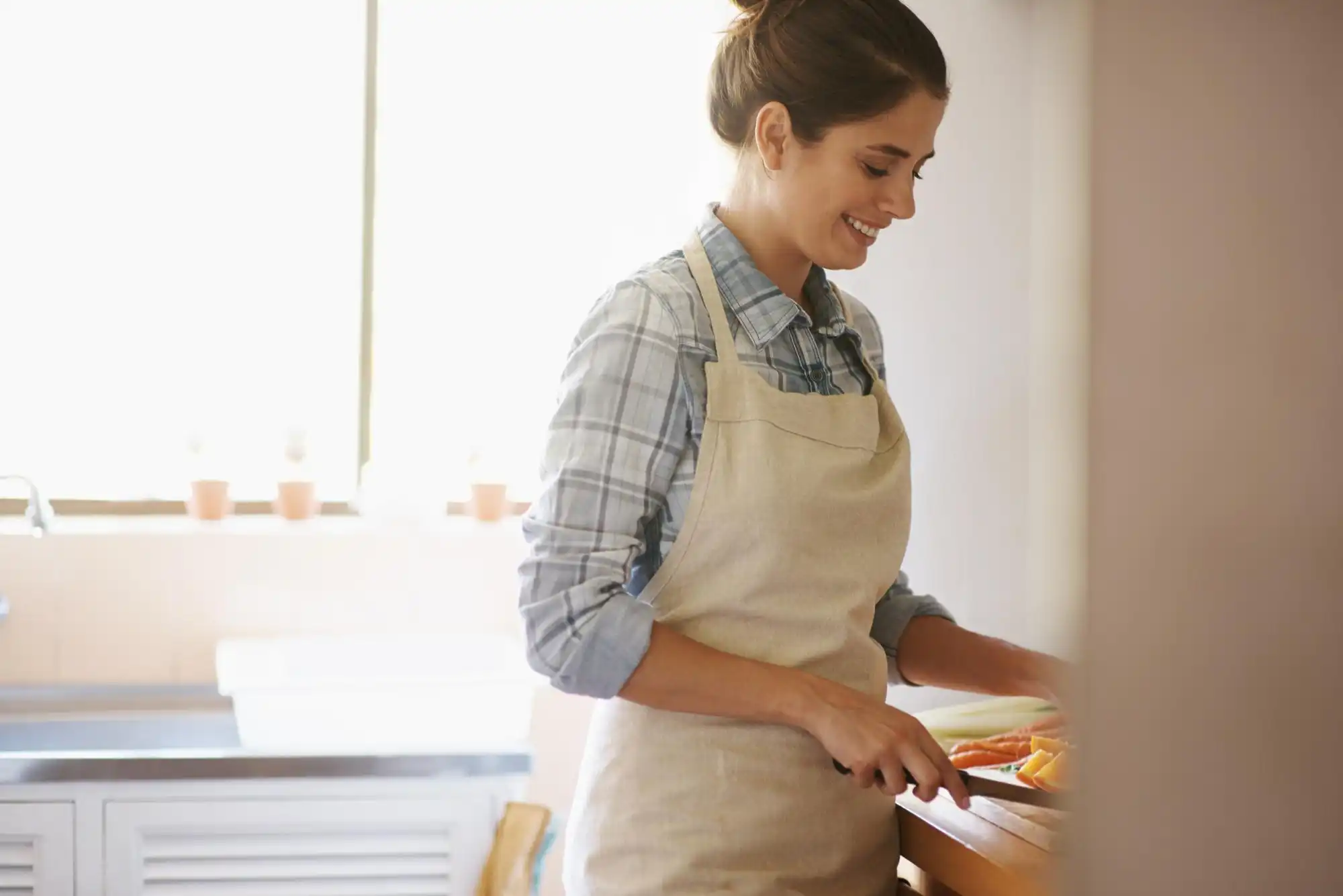 Femme portant un tablier préparant des aliments dans la cuisine