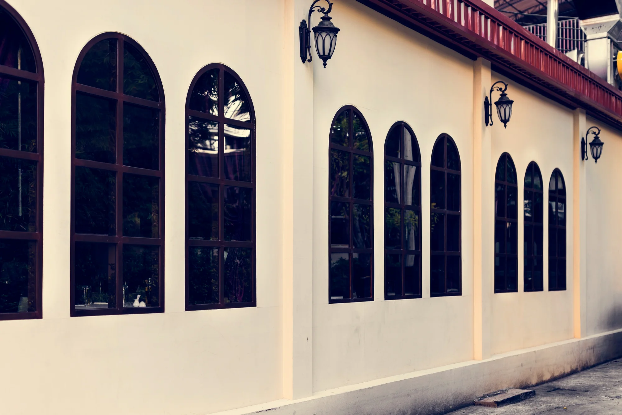 Arched exterior windows on modern cream building facade