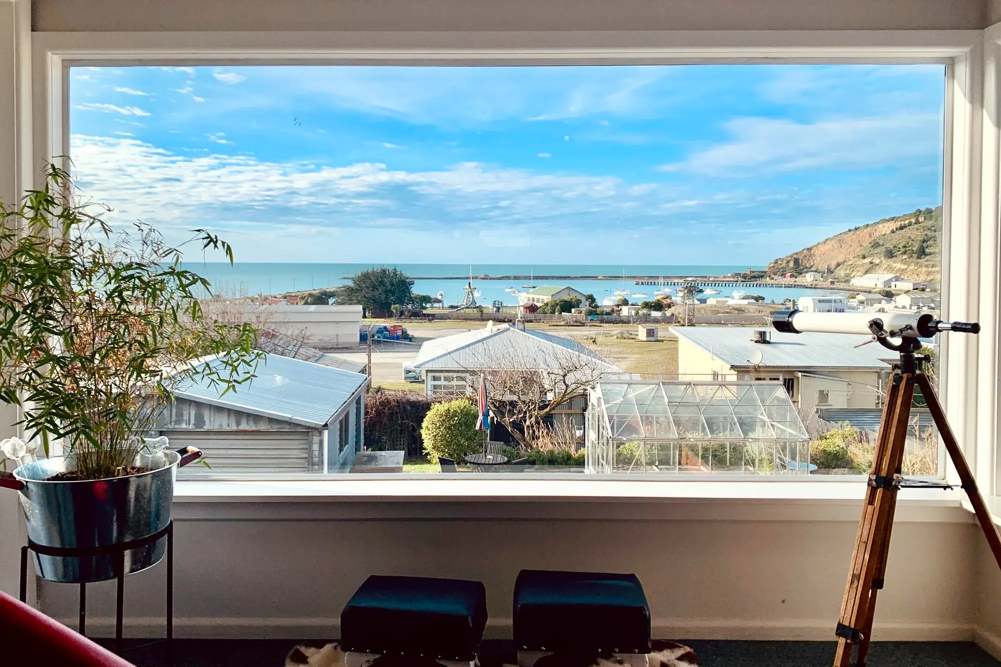 Vista de la casa costera a través de un amplio ventanal con aislamiento térmico.