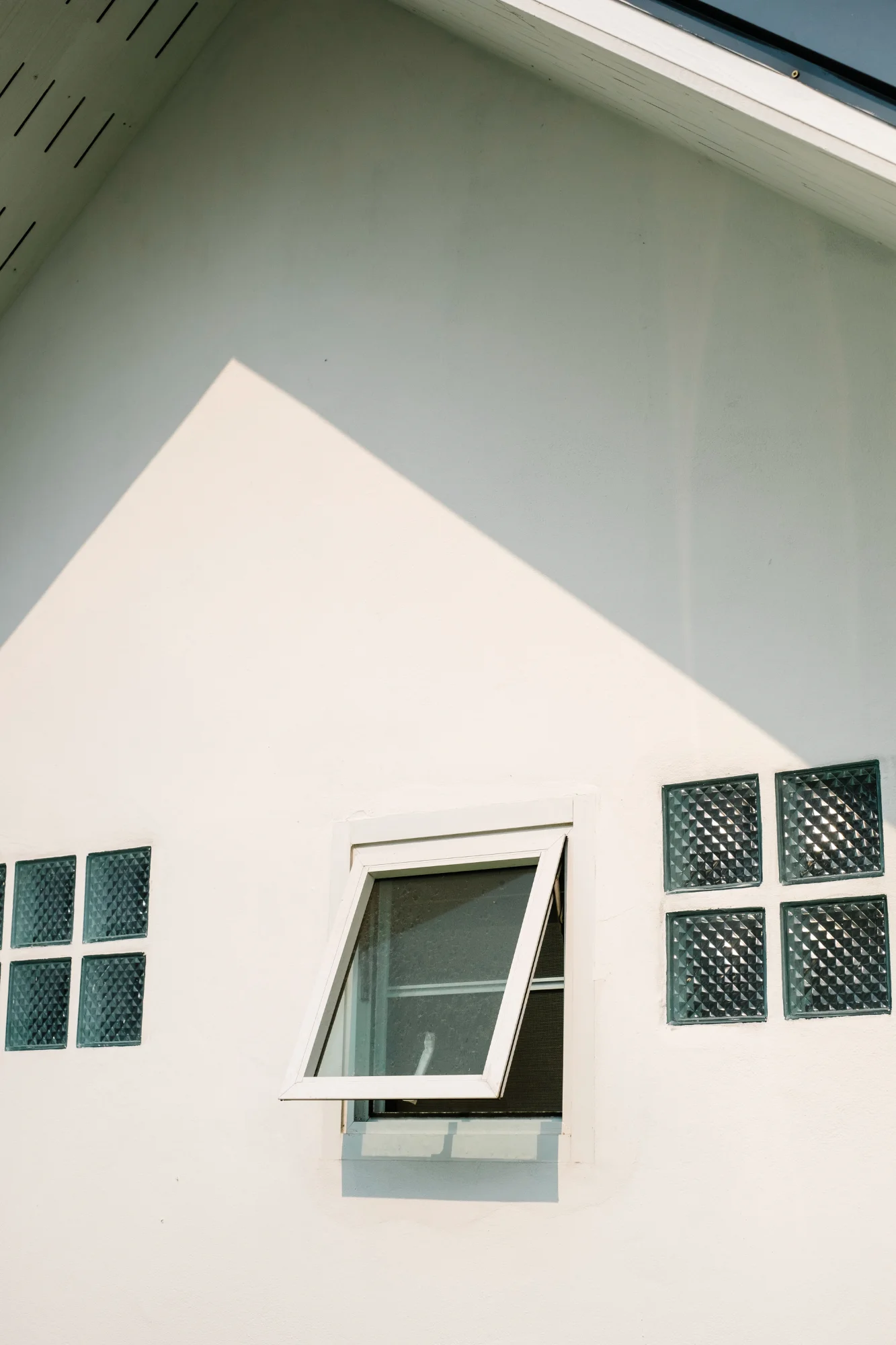 Small awning window on white exterior house wall