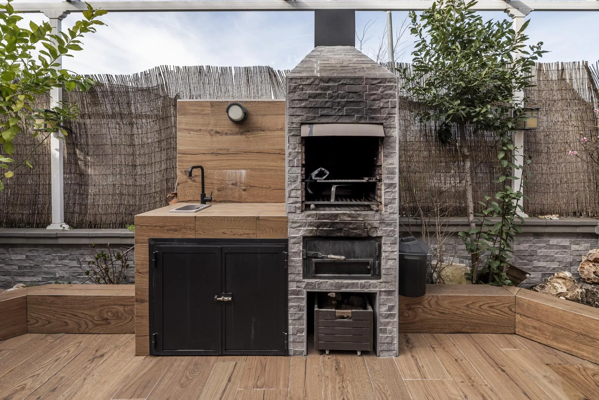Stone outdoor fireplace and kitchen on a wooden deck, mall Outdoor Kitchen Design