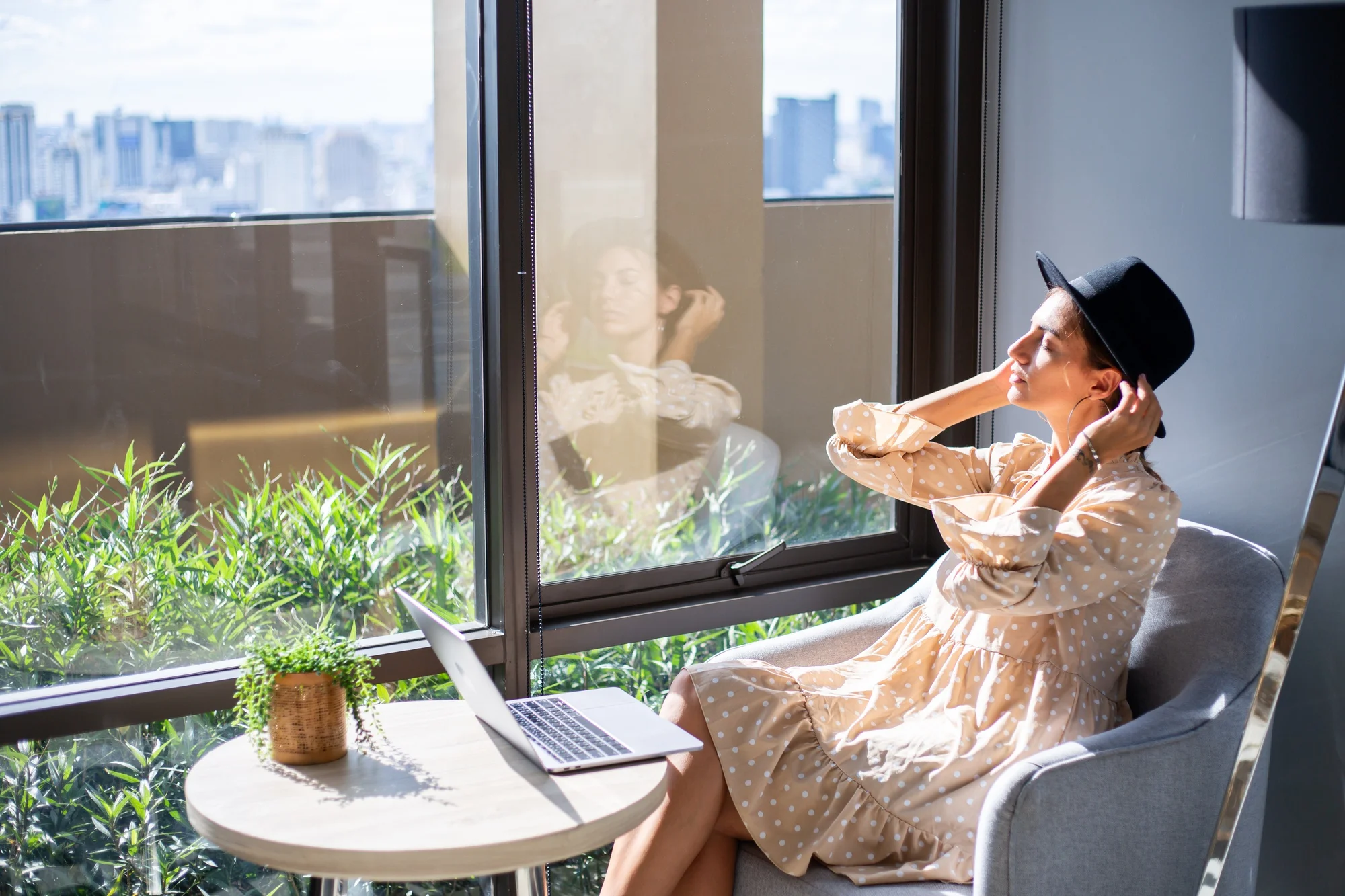Woman relaxing beside large energy efficient picture window