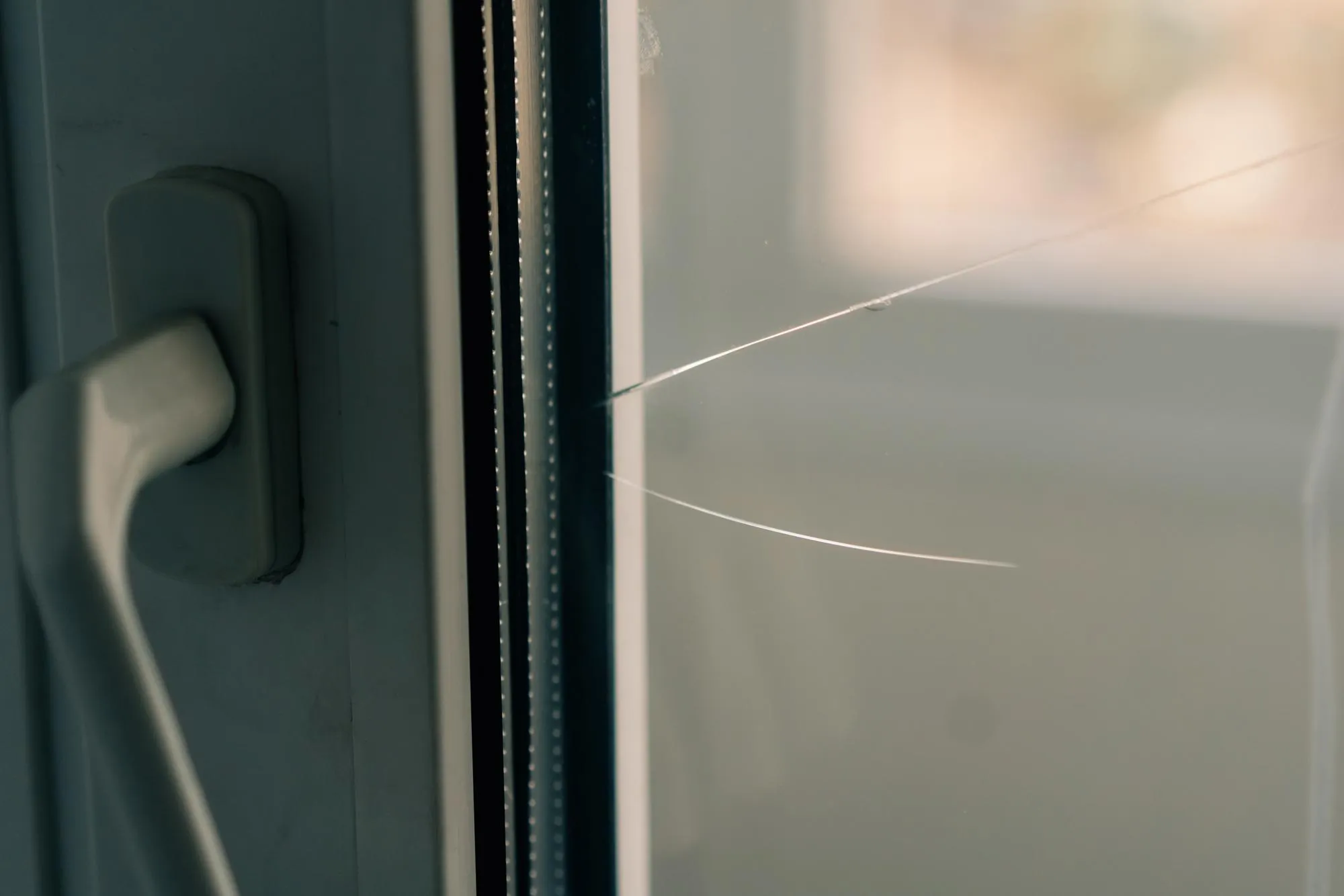 Window with small crack on the glass pane near handle Window with small crack on the glass pane near handle